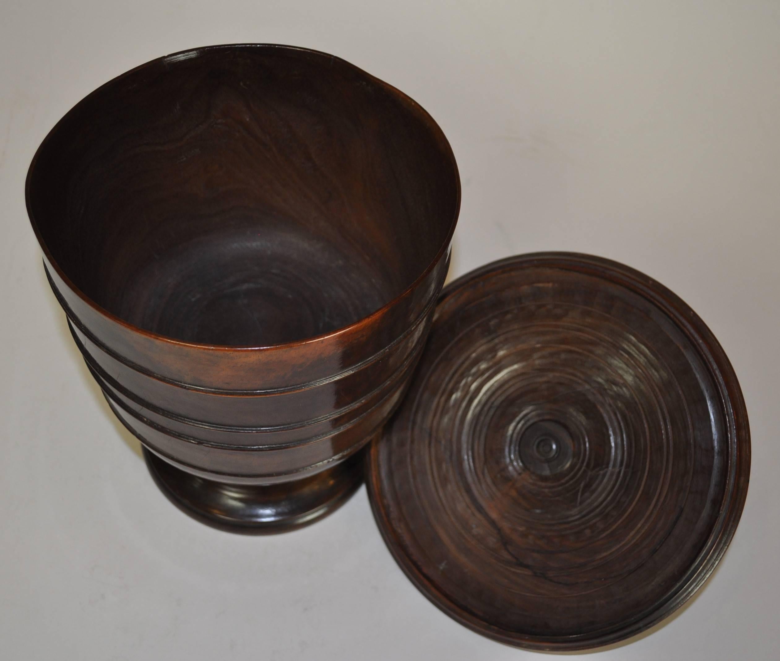 Excellent example of a 17th century Lignum Vitae Wassail bowl of superb color and patina. Retaining it's original lid. The large turned body with central ridge, raised on a pedestal foot. (Replaced finial).
  