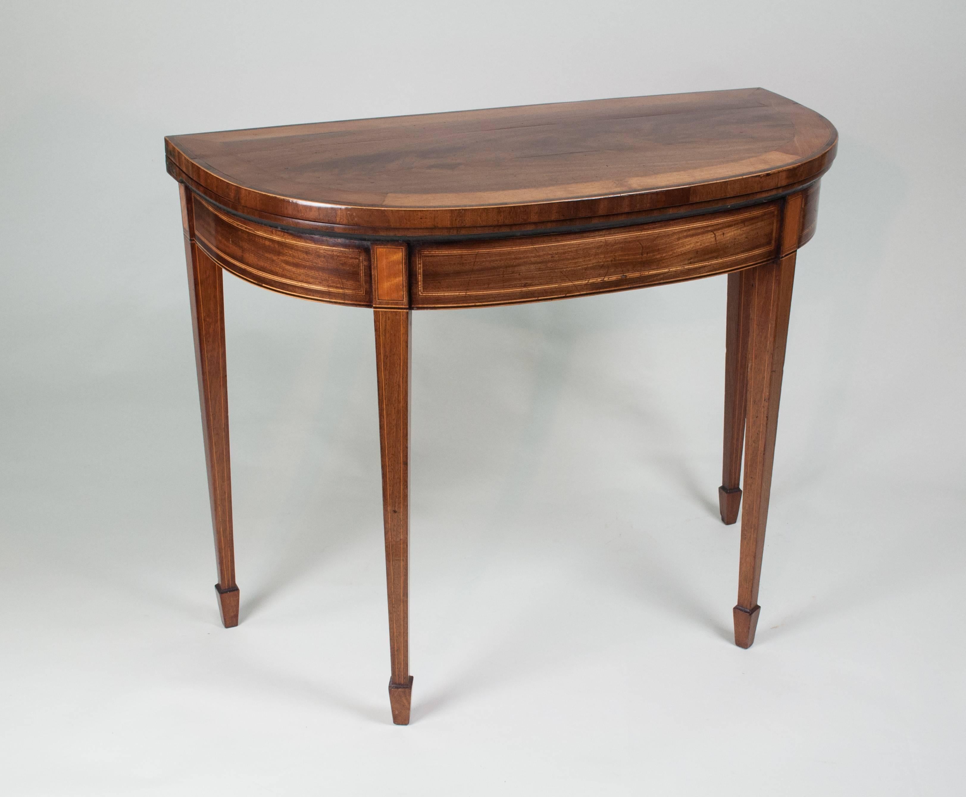 A very fine quality Hepplewhite period well figured mahogany ‘D’ shaped card table, the top with a wide banding of satinwood above a similarly banded apron and standing on square tapering, line-edged legs with spade feet.
I have a very similar