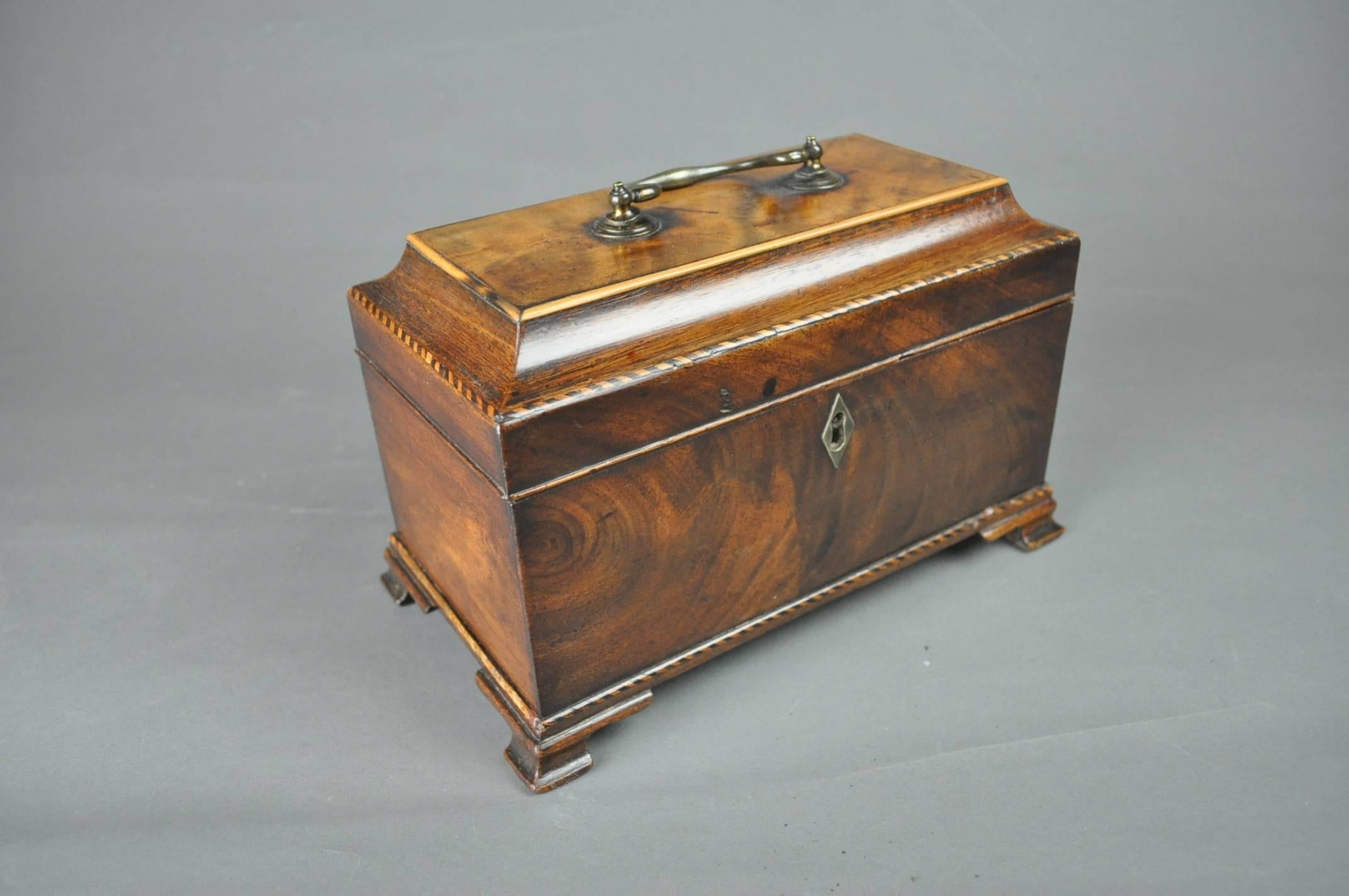 A good Chippendale period mahogany three compartment tea caddy, the raised top with concave edge mouldings and original handle, opening to reveal the three original tin canisters and lids (one lid replaced. Standing on ogee bracket feet.
 