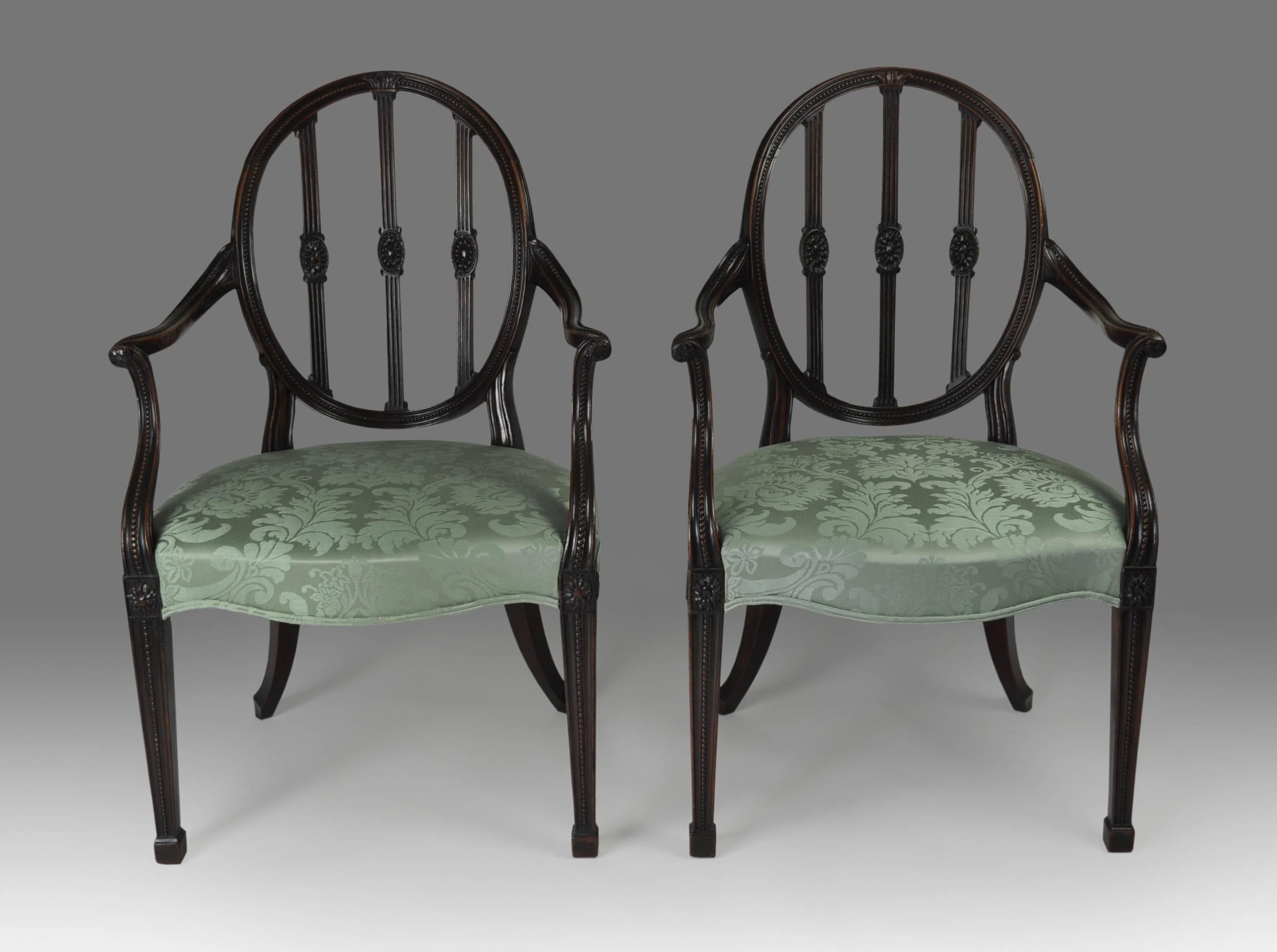 An outstanding pair of late 18th century Adam style mahogany open armchairs, the carved oval backs with beaded hoops enclosing three reeded splats with centred paterae, above out-scrolled beaded arms continuing to square tapered legs with block