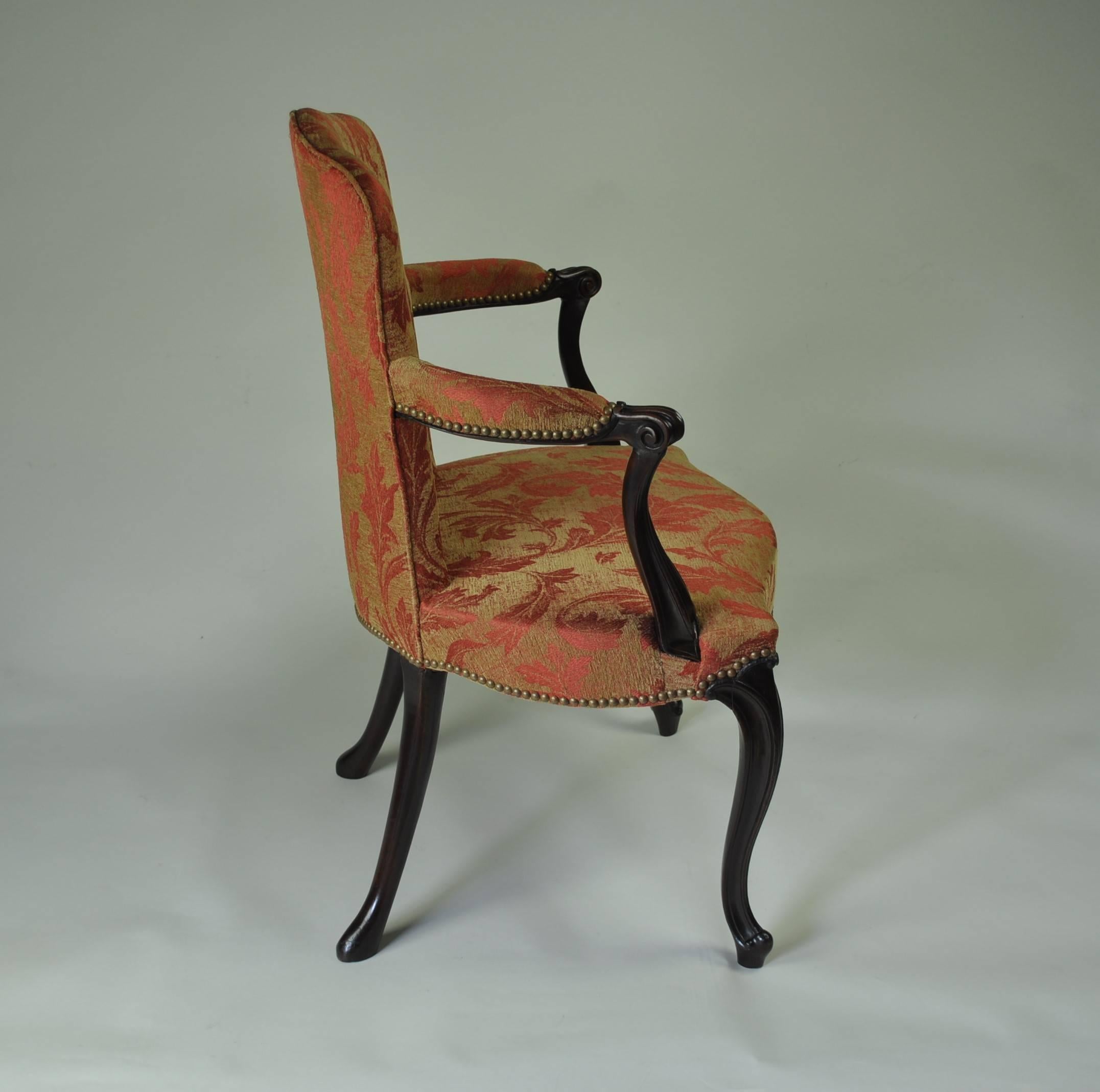 A high quality late 18th century English salon chair of “French Hepplewhite” design, with upholstered back and out-scrolled moulded arms, standing on shaped and moulded cabriole legs and scrolled toes with pad feet at the rear.