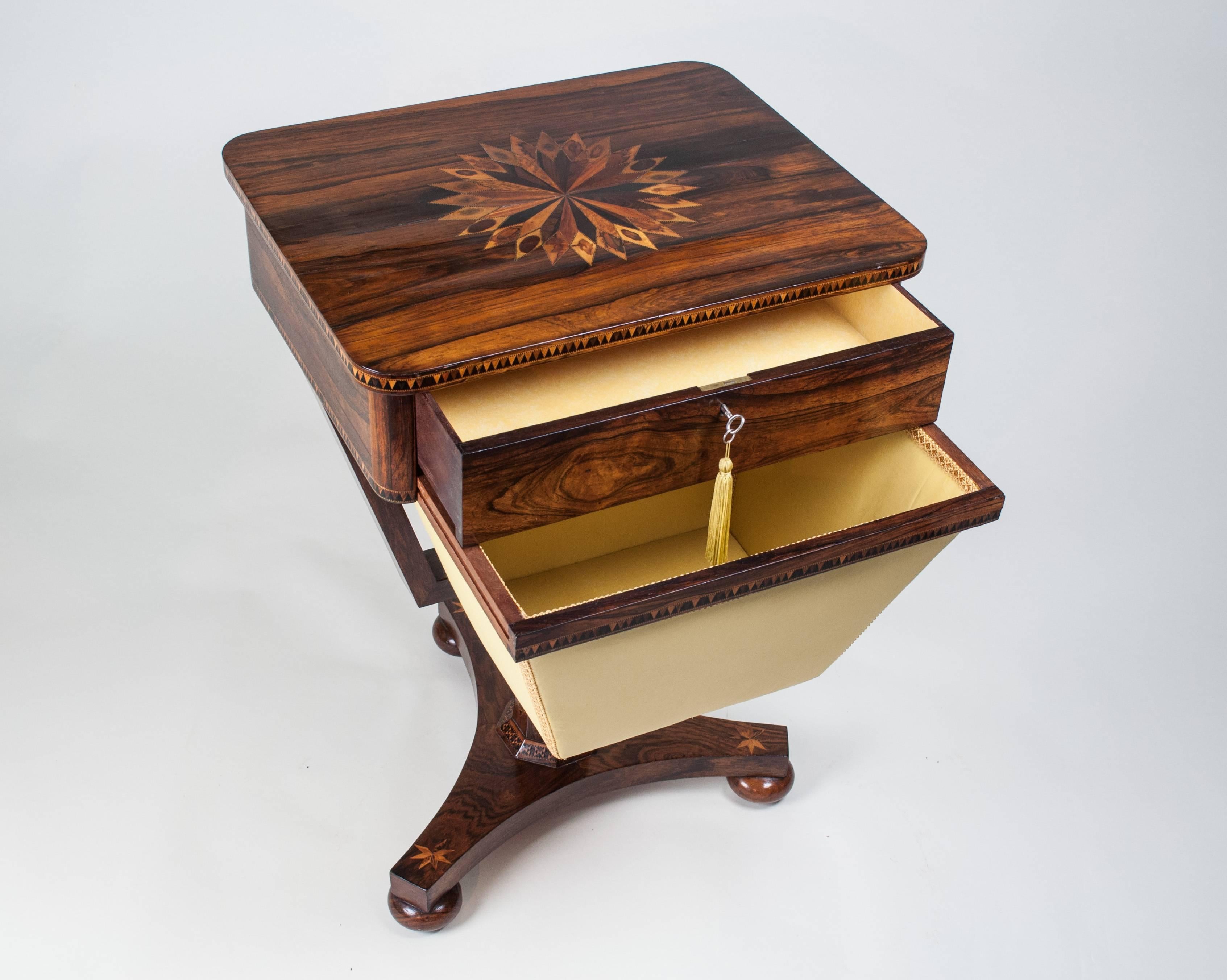 A rare Tunbridge ware Needlework Table. The top inlaid with a specimen wood sunburst, above a silk-lined apron drawer set between bands of 'Vandyke pattern' Tunbridge banding. Below, a silk-covered box held in a frame and supported on an octagonal