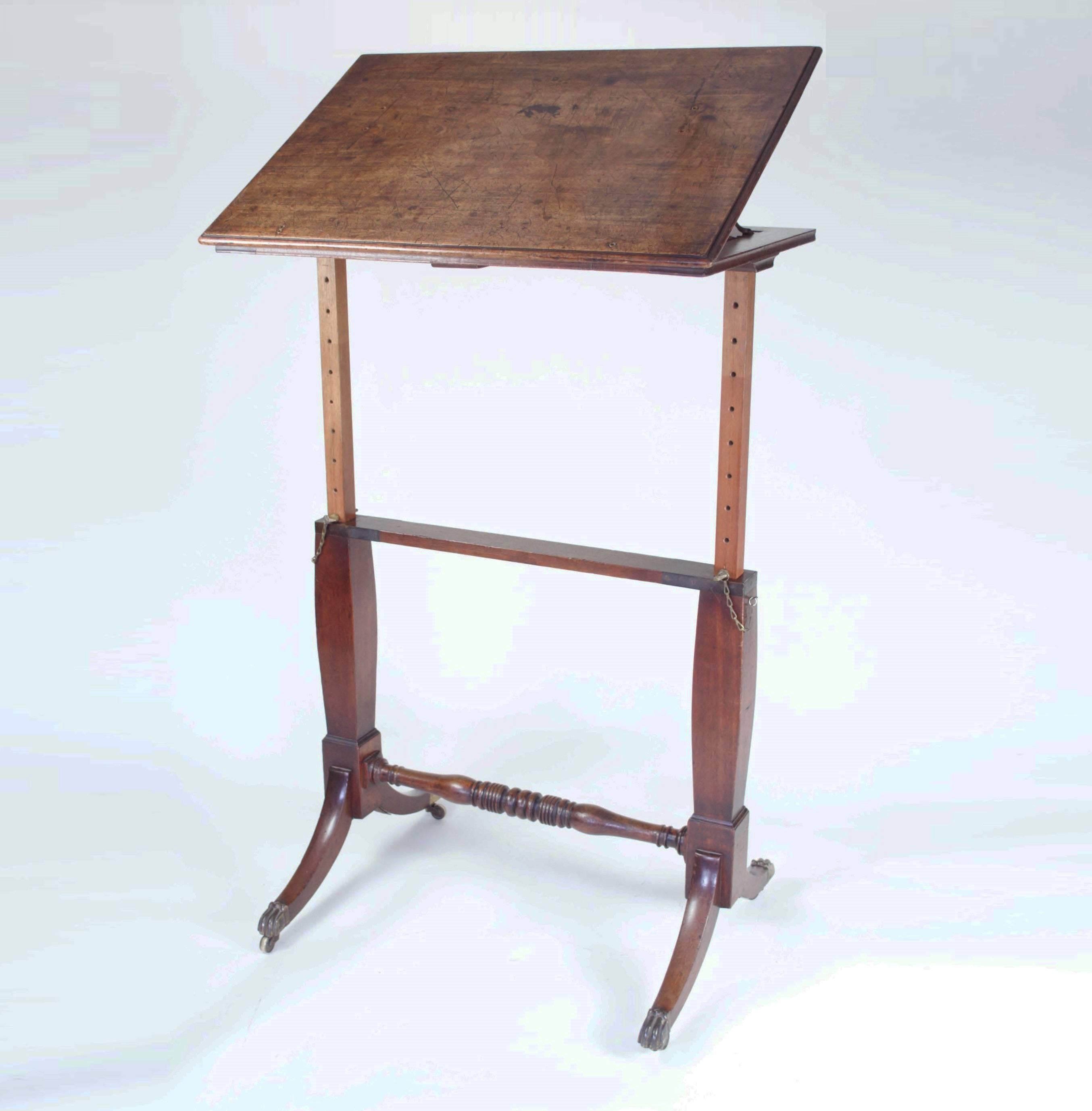 An unusual early 19th century adjustable artist's table, reading stand or lecturn with ratcheted top raised on end supports allowing several differing heights between 76cms and 127cms and resting on swept legs ending in brass animal paw caps and