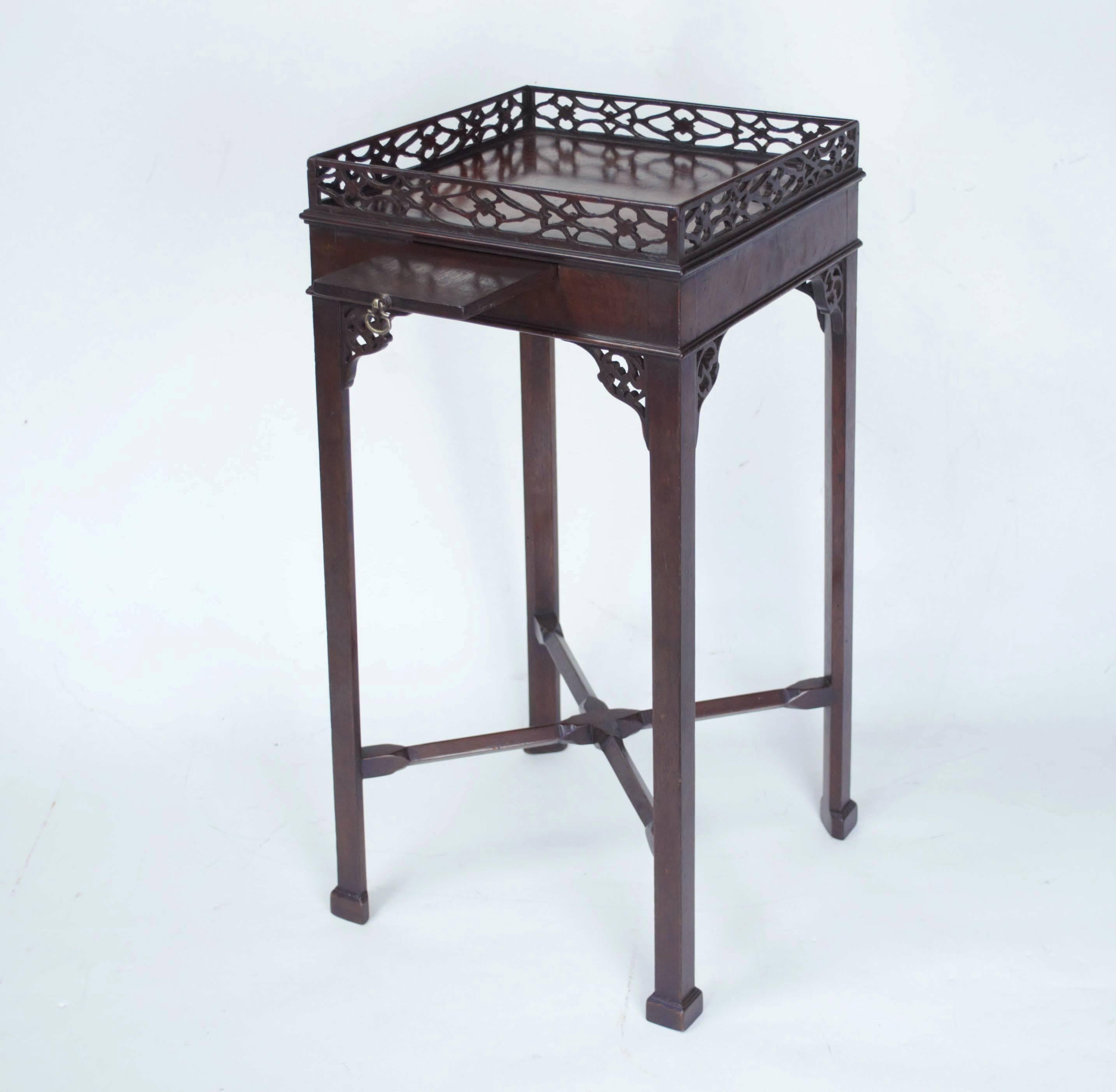 A fine quality Chippendale inspired mahogany urn or kettle stand of square form with open-fret galleried top above a moulded edged apron set with a cup slide in the front, and standing on elegant and unusual triangular legs with block toes and