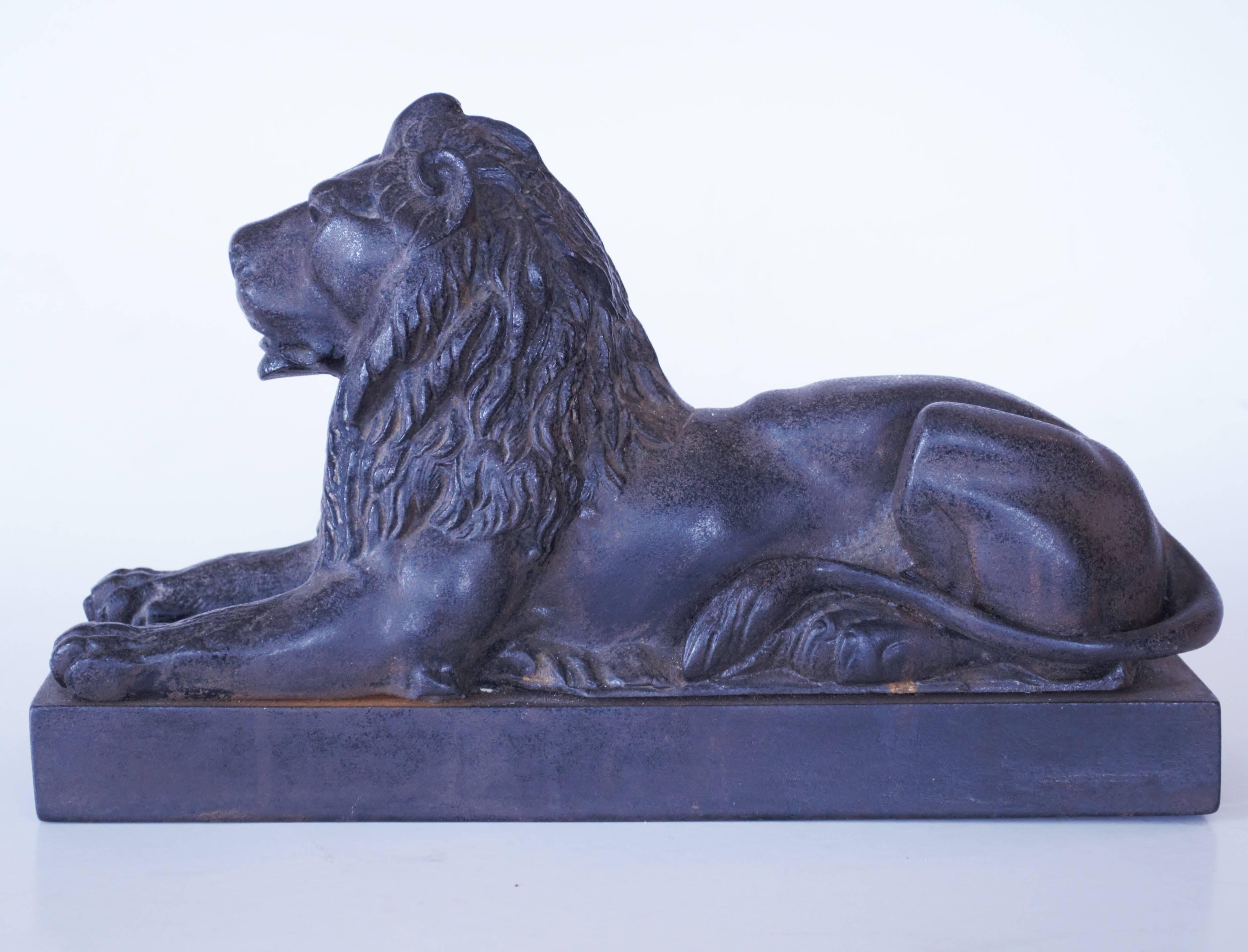 A pair of decorative 19th century cast iron reclining lions after the magnigicent original bronze pair by Sir Edwin Landseer displayed in Trafalgar Square.