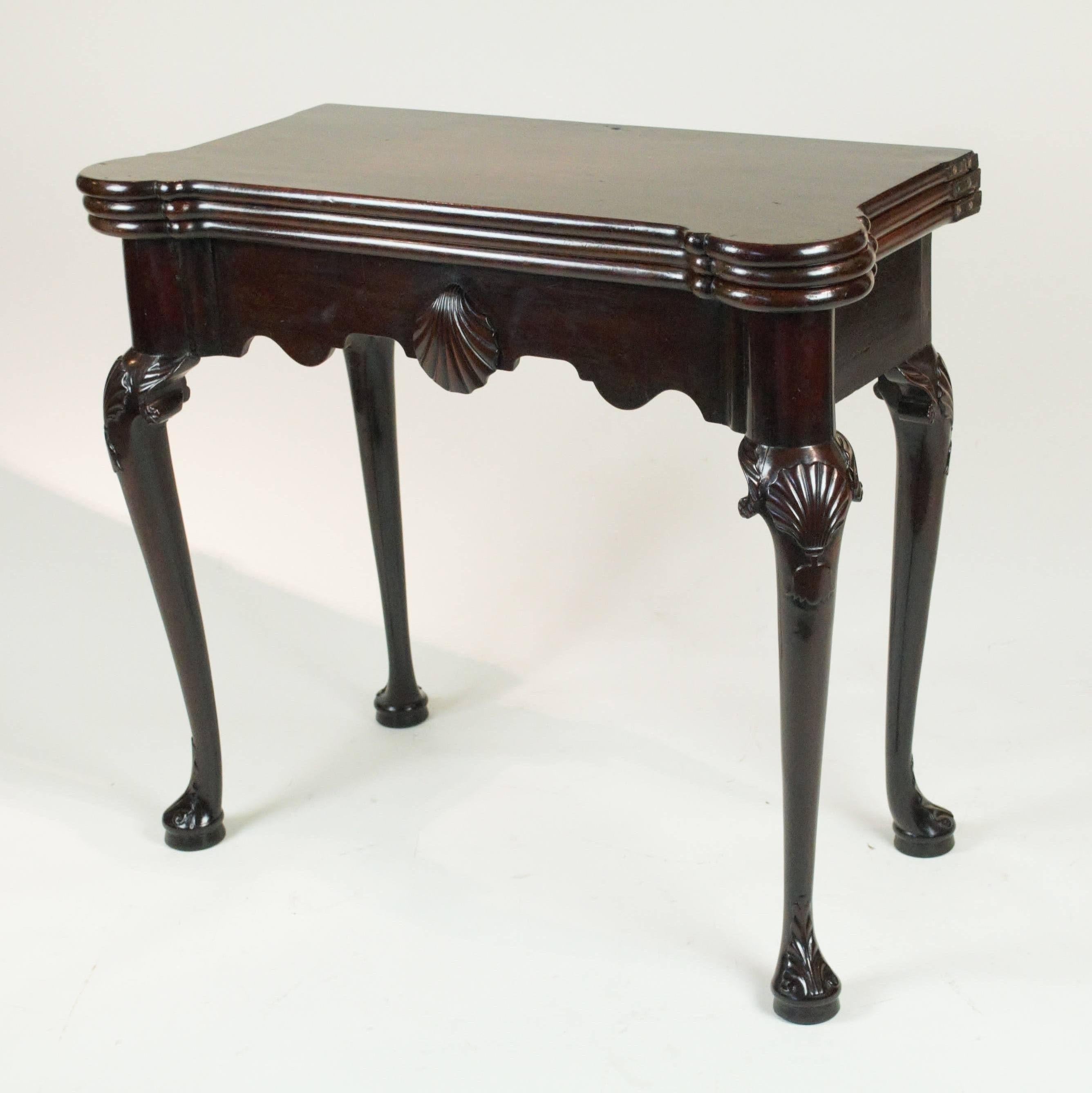 An exceptional and rare mid-18th century Cuban mahogany Irish "castle-top" card and tea table. The shaped top consisting of three flaps which fold open to create either a tea table or a baize-lined card table with candle-stands and counter