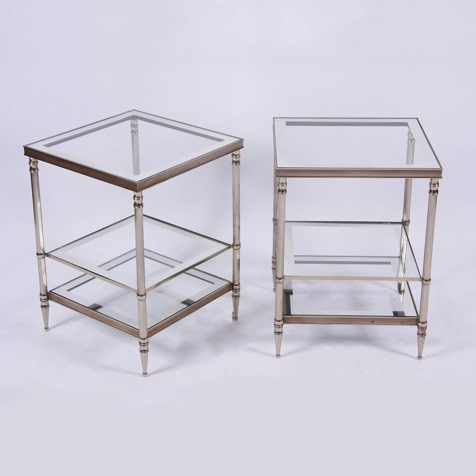 A stunning pair of French Mid-Century metal side tables, nickel-plated with fluted legs and tapering feet. Three tier with clear glass with an antiqued mirror edge.

Measures: Height 54cm, width 40cm, depth 40cm.