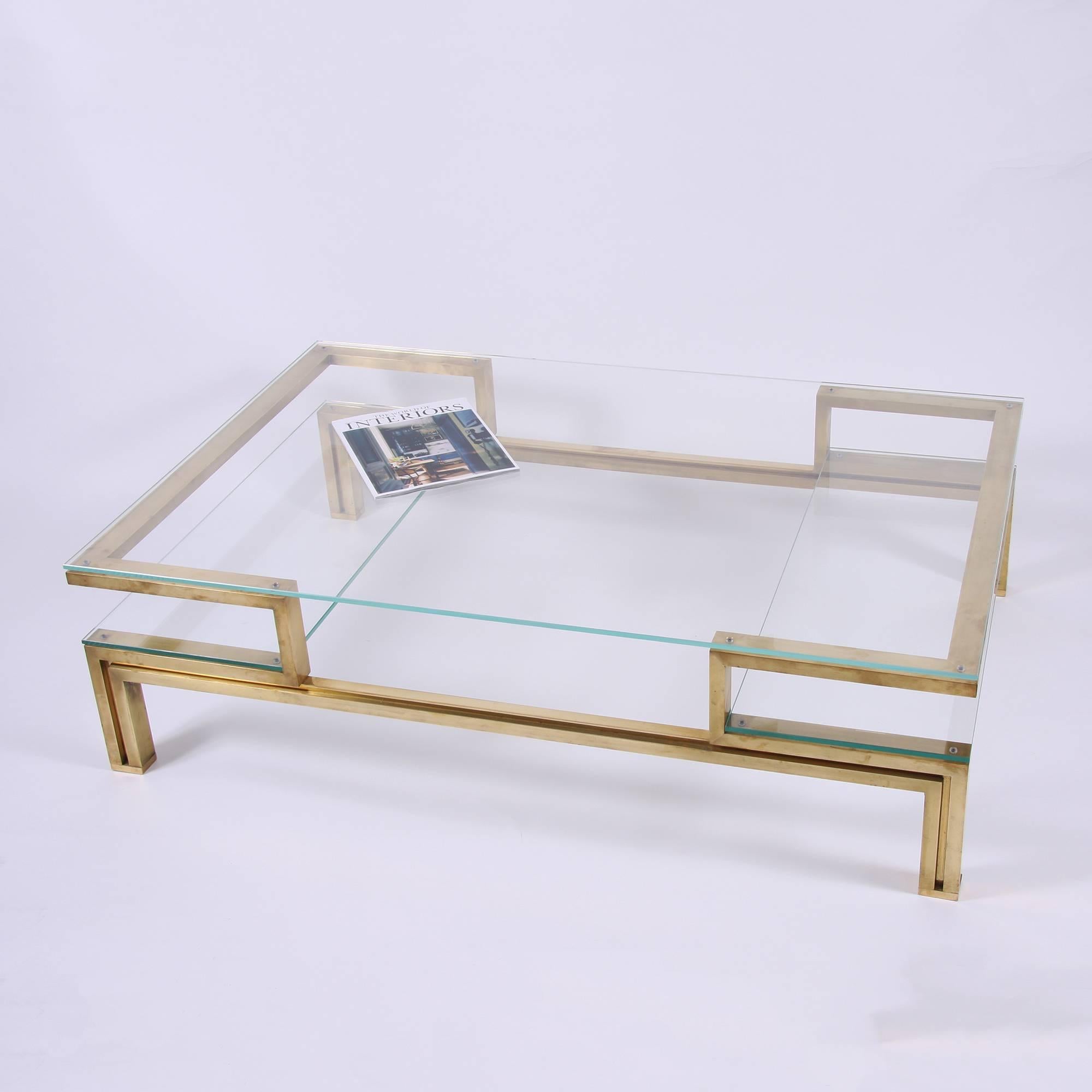 A fantastic quality French brass coffee table with two side 'shelves' for display or magazines. This table has a fabulous design. With new toughened glass.