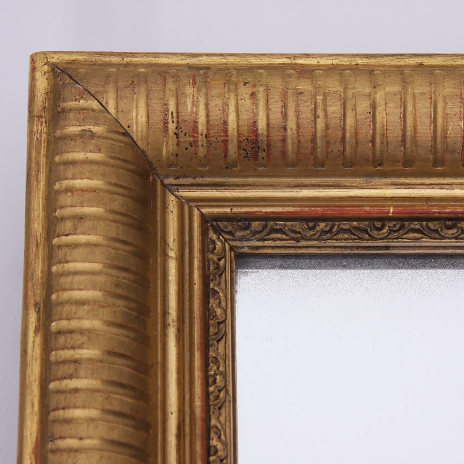 Tall, slim giltwood mirror, with a reeded frame and inner detail. Original plate and back boards.