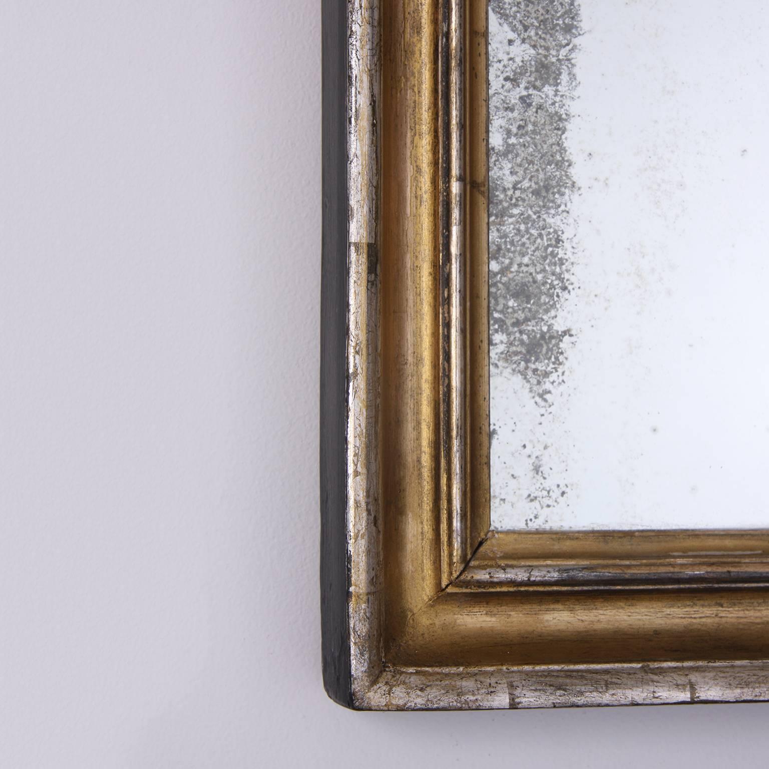 Small mirror with a two tone frame, gilded and silver leaf. Original plate with a lovely age to the glass.