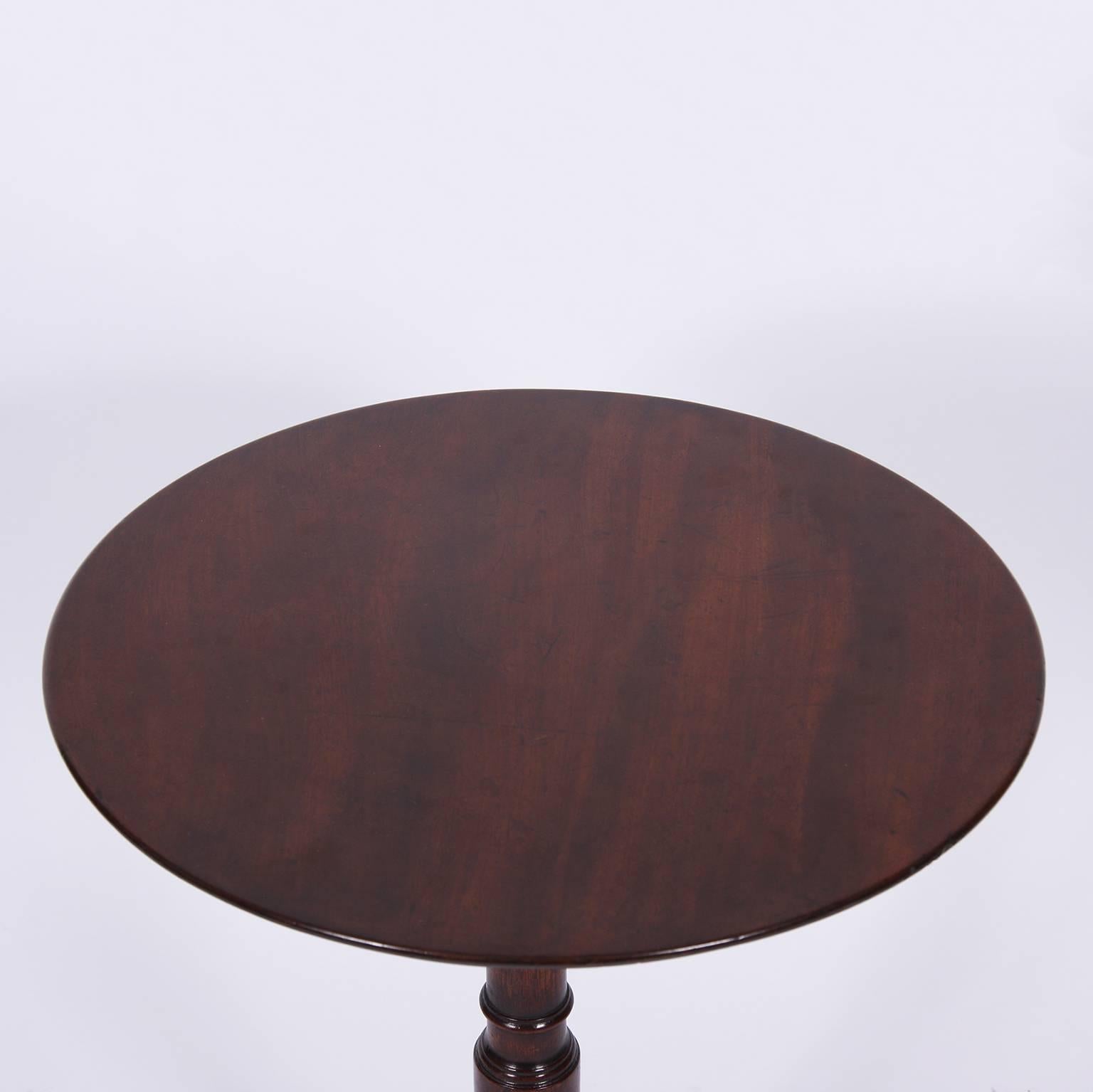 Occasional snap top mahogany table with a triform base and turned pedestal. This is a beautiful early 19th century piece.