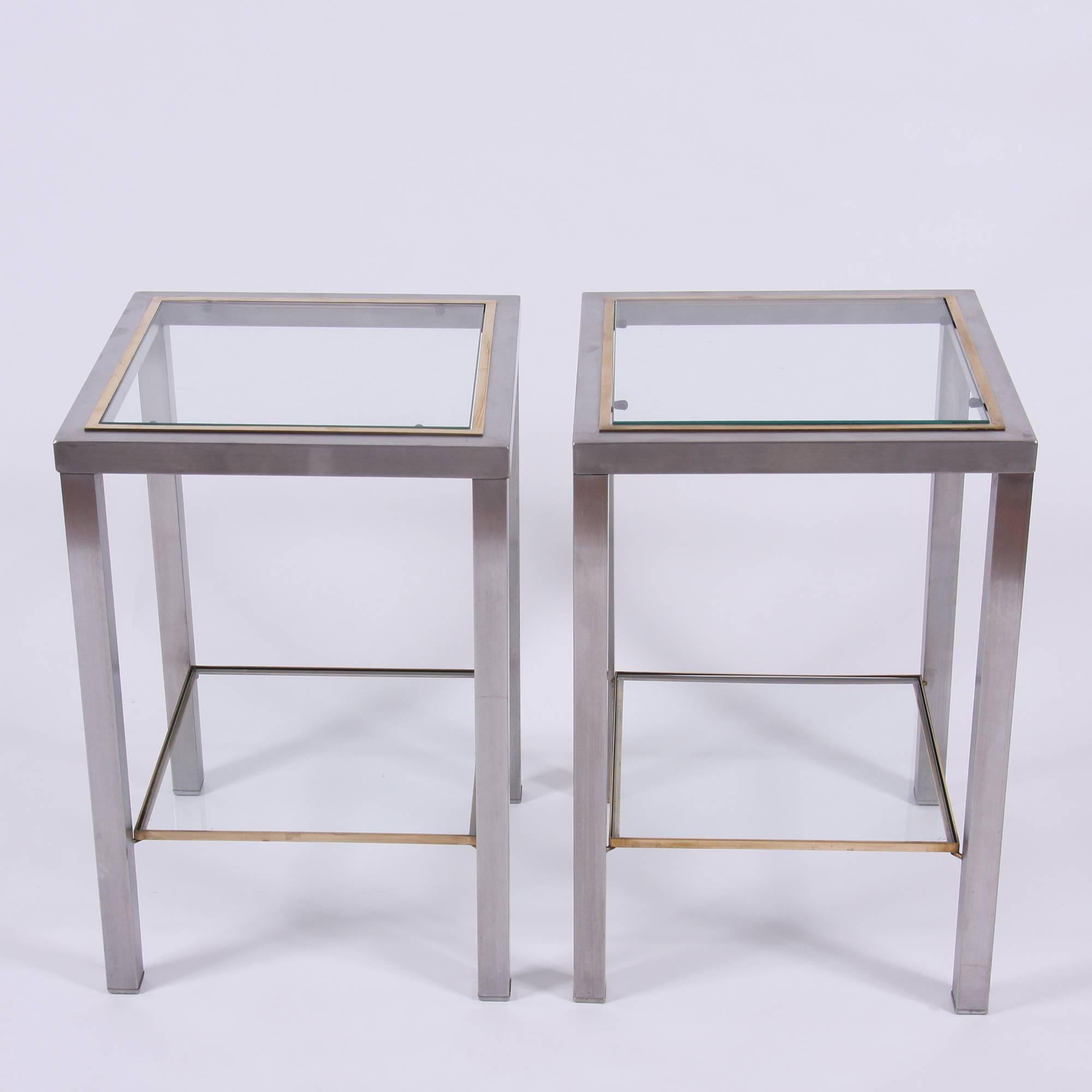 A great pair of Mid-Century two-tier side tables. These tables are made from brushed steel with brass detailing.
