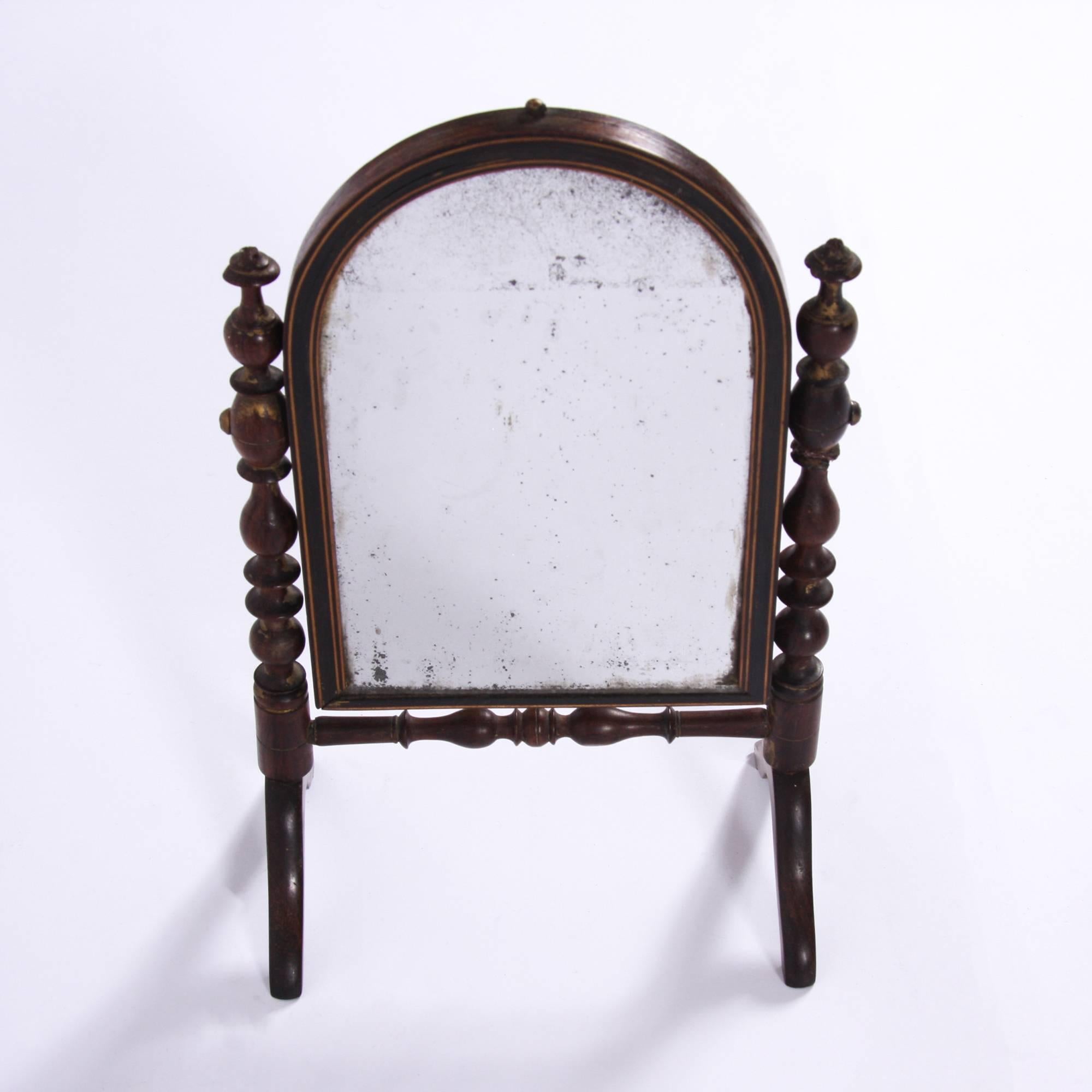 English, 19th century

A miniature Campaign mirror made from turned mahogany with original sparkly mercury glass. The feet fold flat for travel.