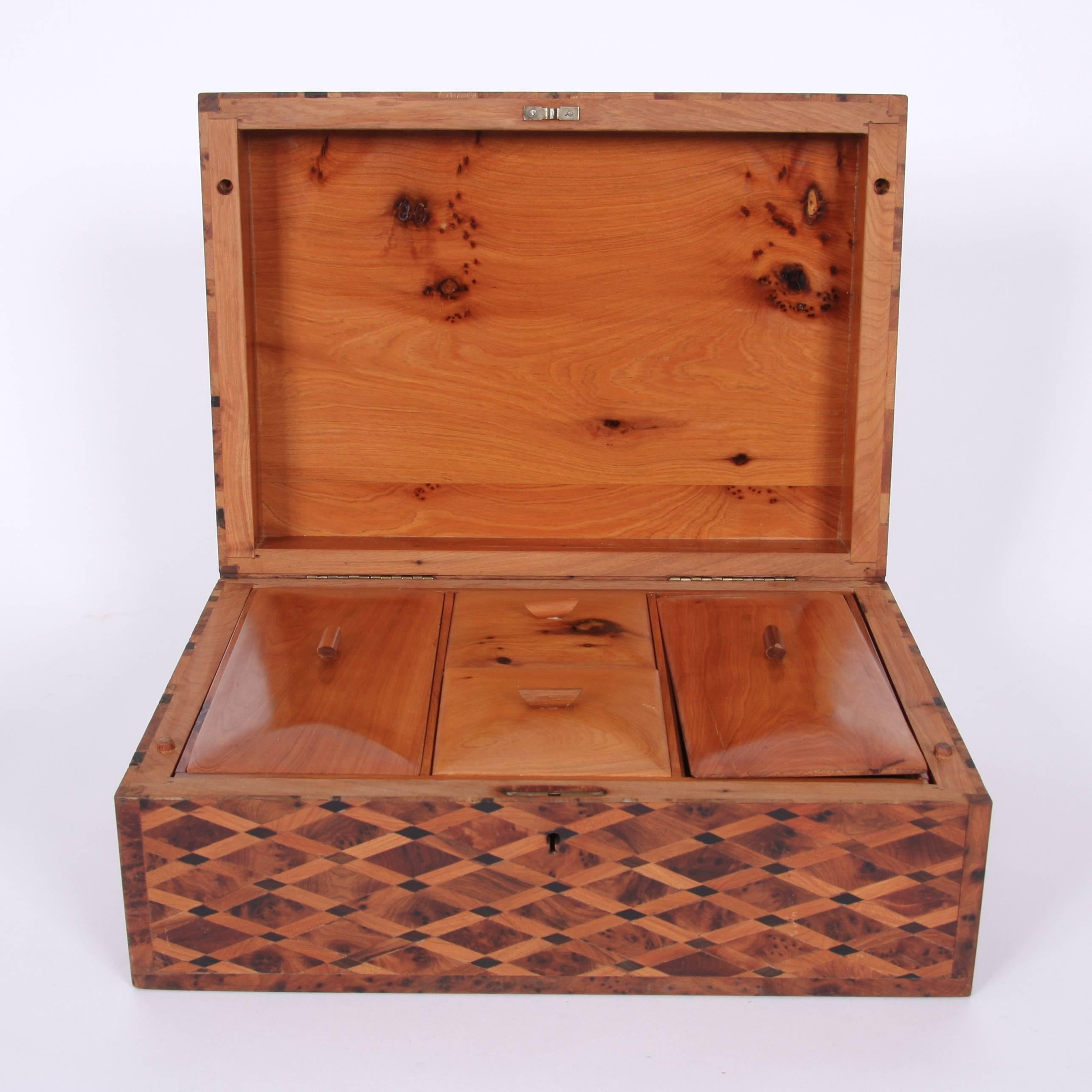 French, mid-20th century.

A beautiful parquetry design wooden box, suitable for use as either a sewing or trinket box or even as a jewelry box. Lid lifts up to reveal a tray that lifts out and smaller lidded compartments.