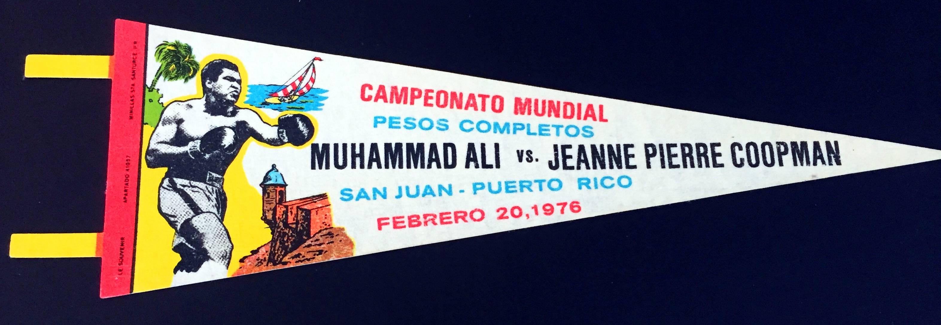 Muhammad Ali
Vintage original, like new, souvenir pennant: Muhammad Ali versus Jeanne Pierre Coopman, February 20, 1976 at the Roberto Clemente Coliseum in San Juan, Puerto Rico. 

Bold crisp colors; excellent print quality. No tack holes. 
27.5