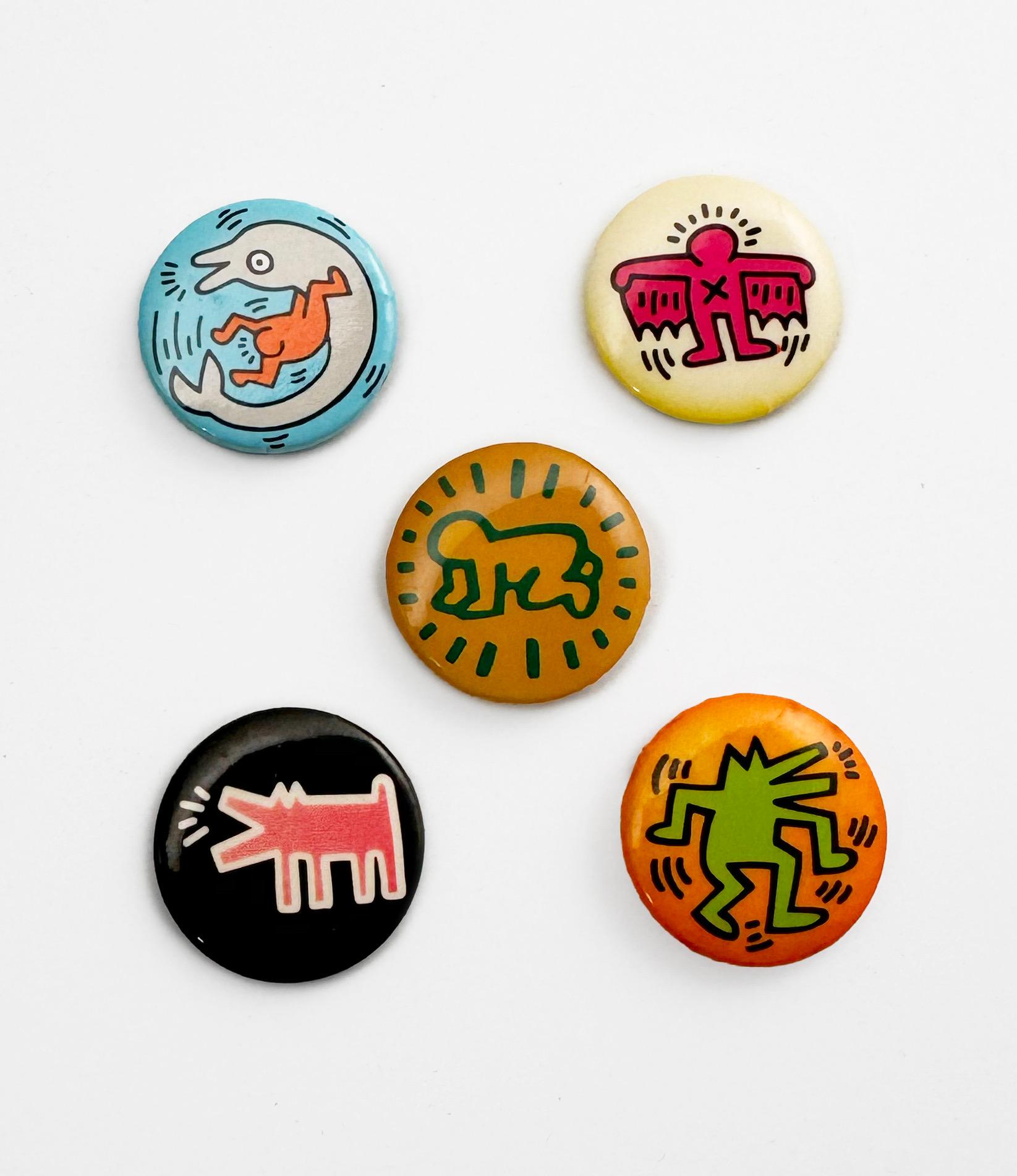 Un ensemble de 5 pins de revers vintage Keith Haring Pop Shop, datant de 1986-1987 et représentant certaines des images les plus emblématiques de l'artiste.

Original vers le milieu des années 1980 (pas de reproductions ultérieures) 
Petites