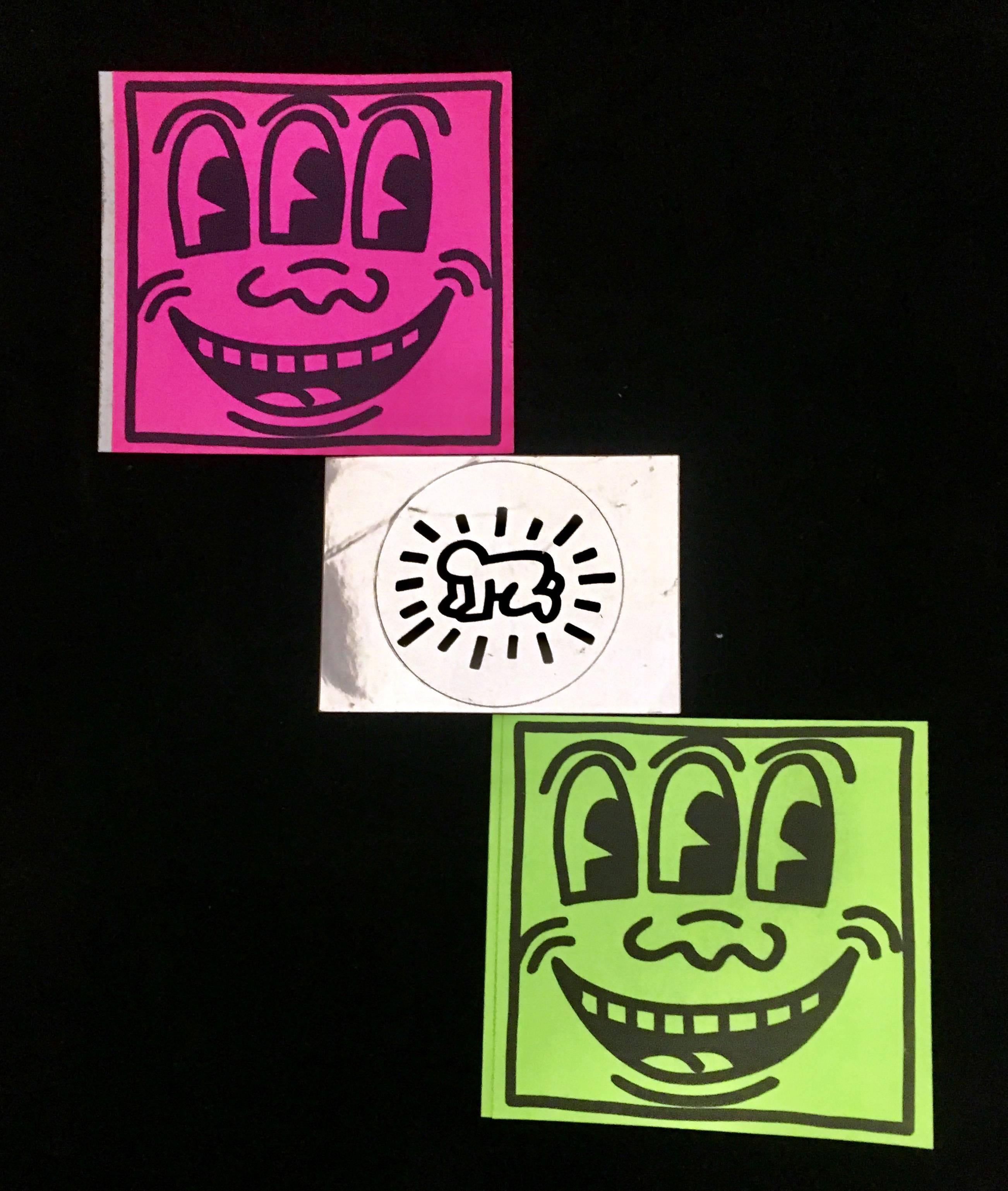 A set of three vintage Keith Haring Pop Shop stickers c.1986: Radiant baby; and Neon Pink Three Eyed Smiling and Neon Green Three Eyed Smiling Stickers.

Early 1980's. Each unused and in very good condition
Smiling faces 3 to 4 inches square in