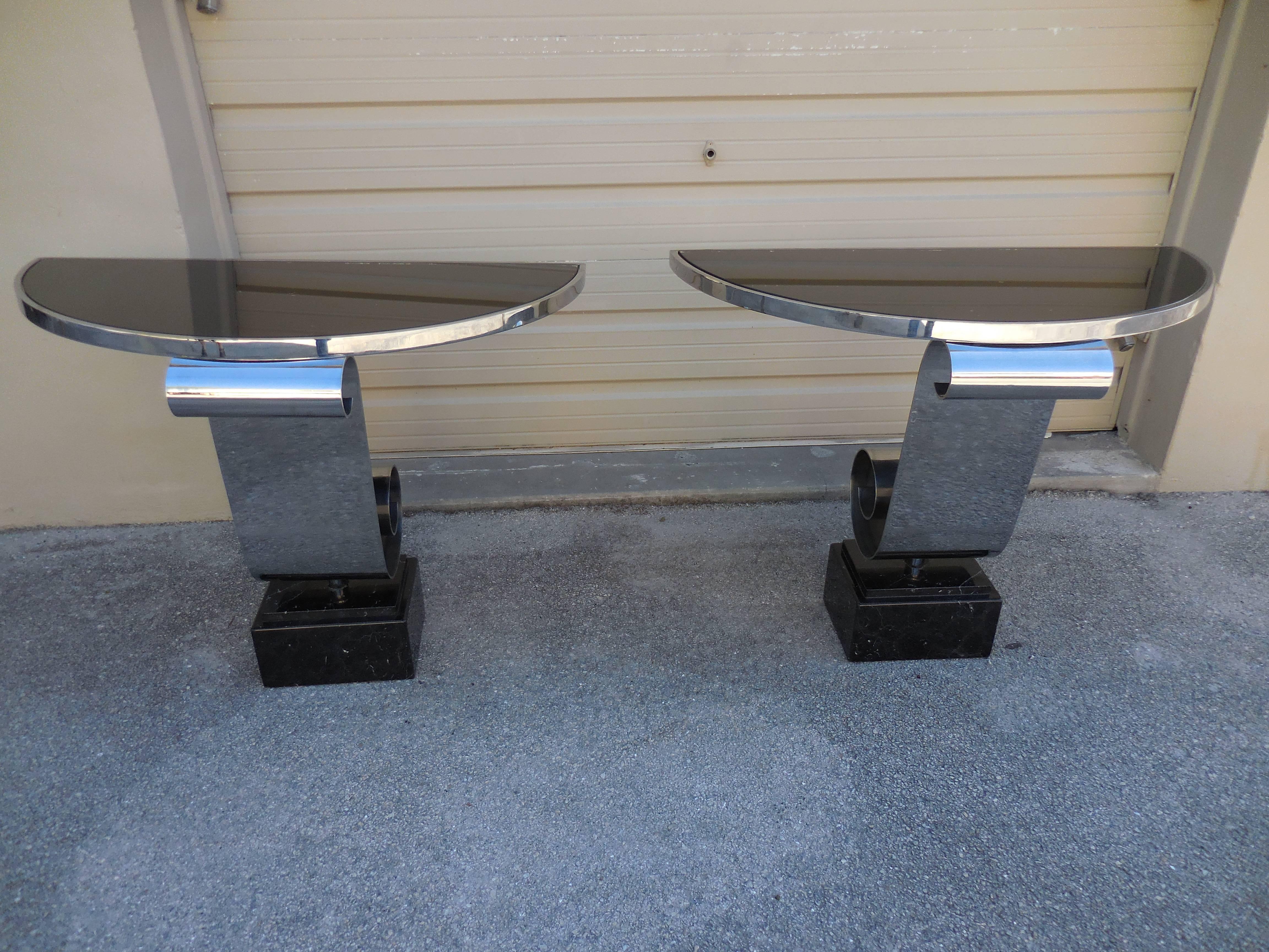 Beautiful pair of Mid-Century demilune tables. Stainless steel and marble base, topped with glass. Gorgeous pair.