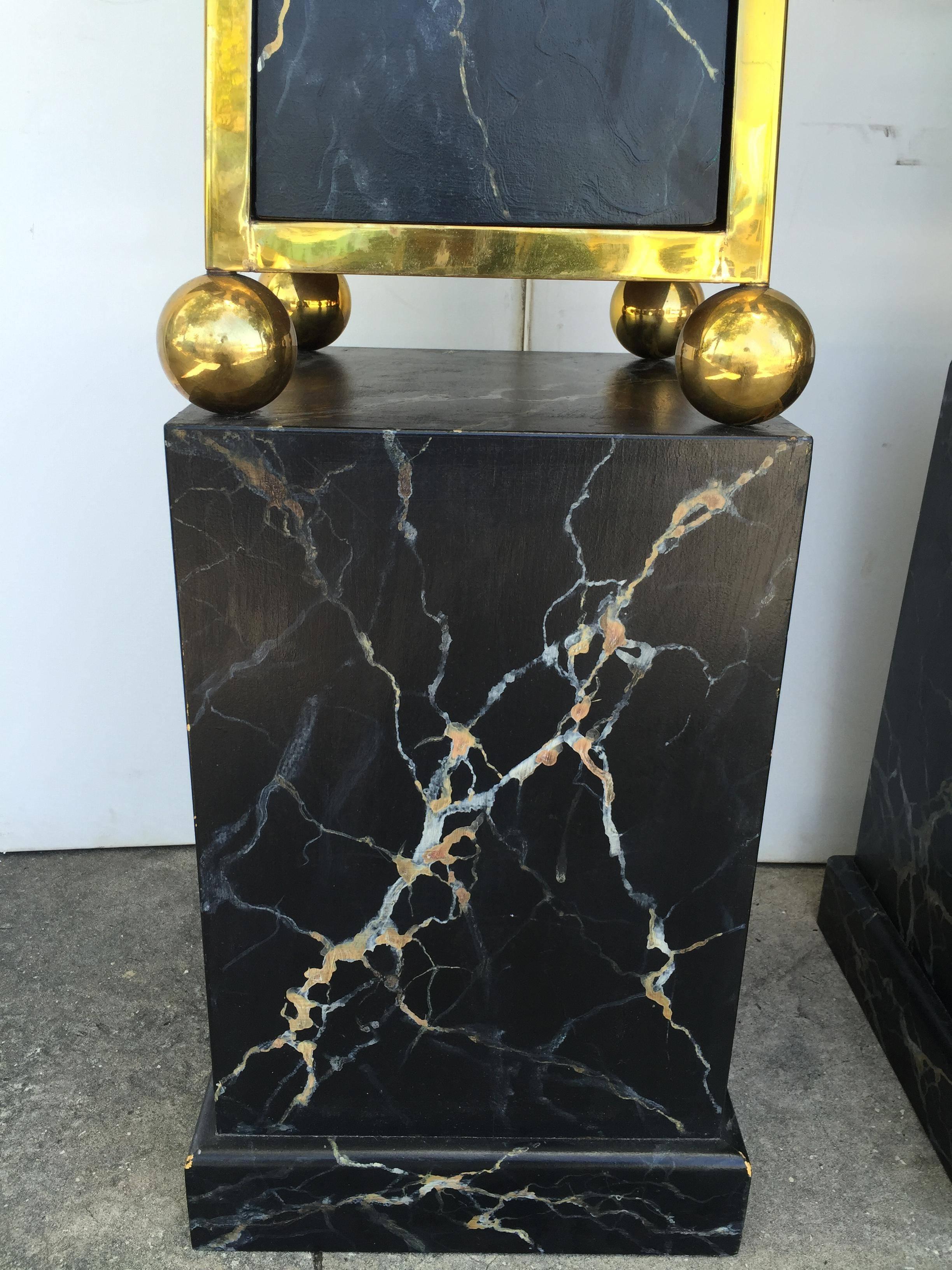 Beautiful pair of Mid-Century faux marbled obelisk pedestals with two interior glass shelves in each.