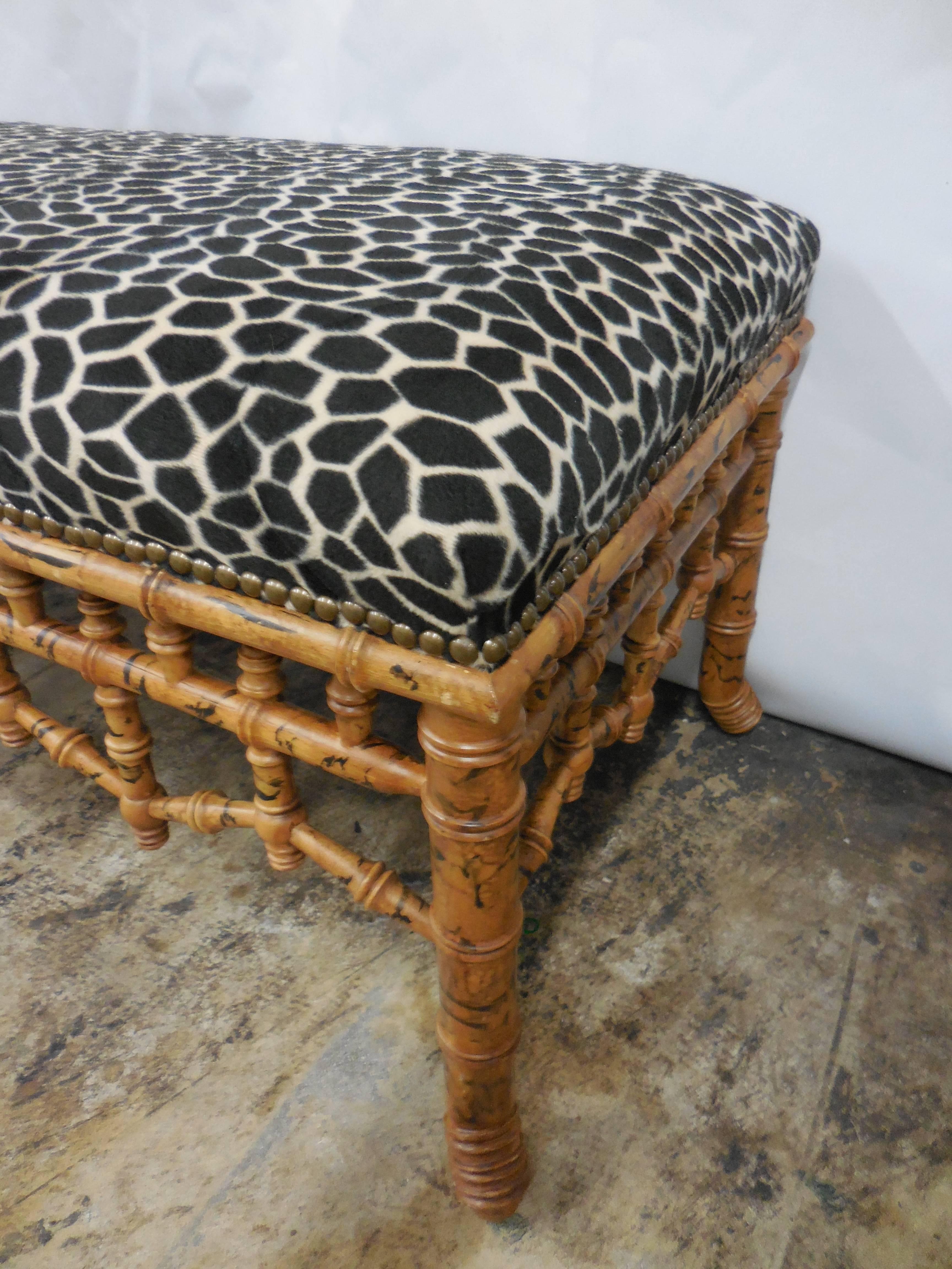 Chic Mid-Century bamboo bench with soft leopard fabric and nailhead trim.