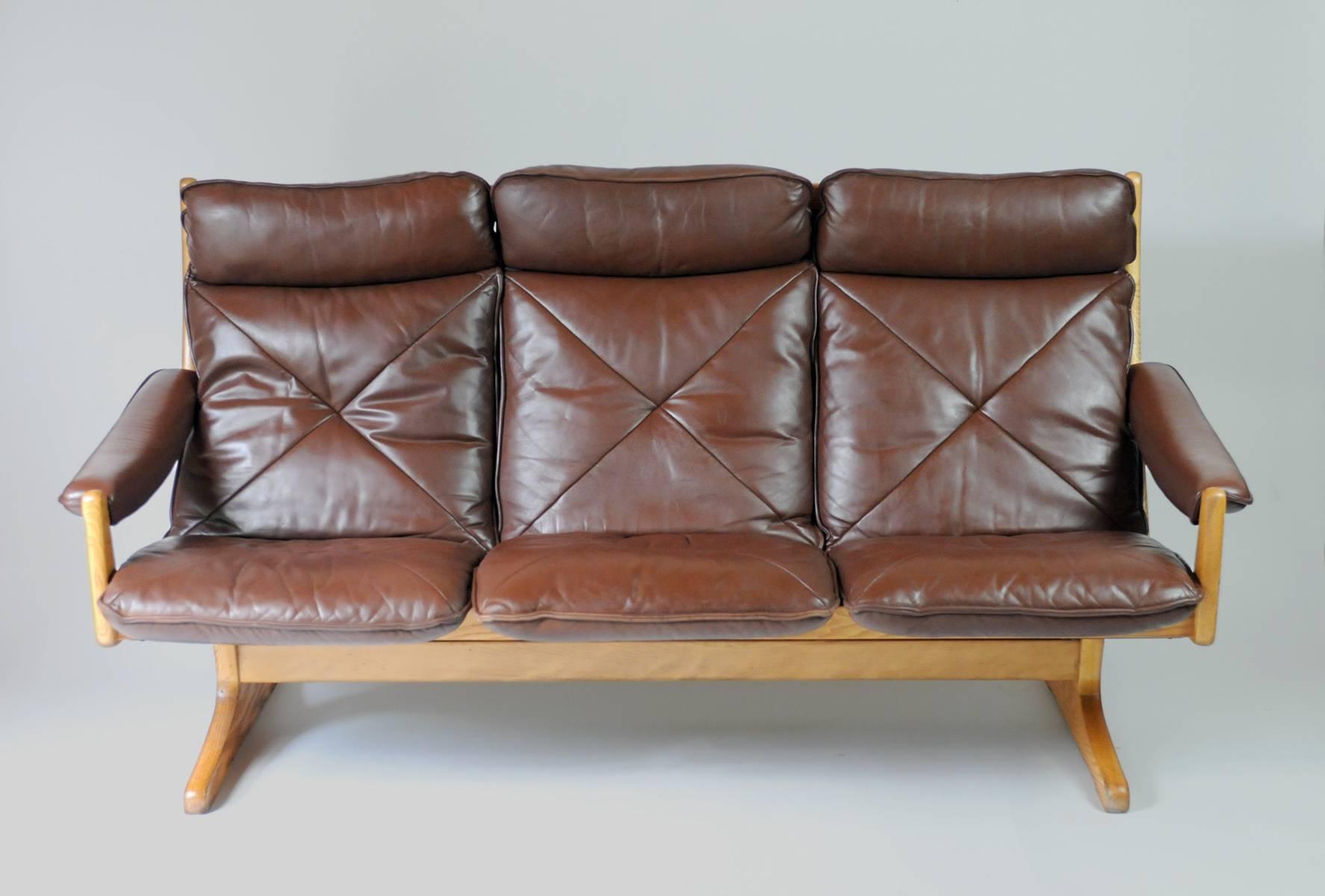 This solid ash and leather three-seater sofa was produced in Norway by Soda Galvano during the 1960s. It features a solid ash frame and patinated leather upholstery. Comfortable and solidly built, this sofa has been restored.