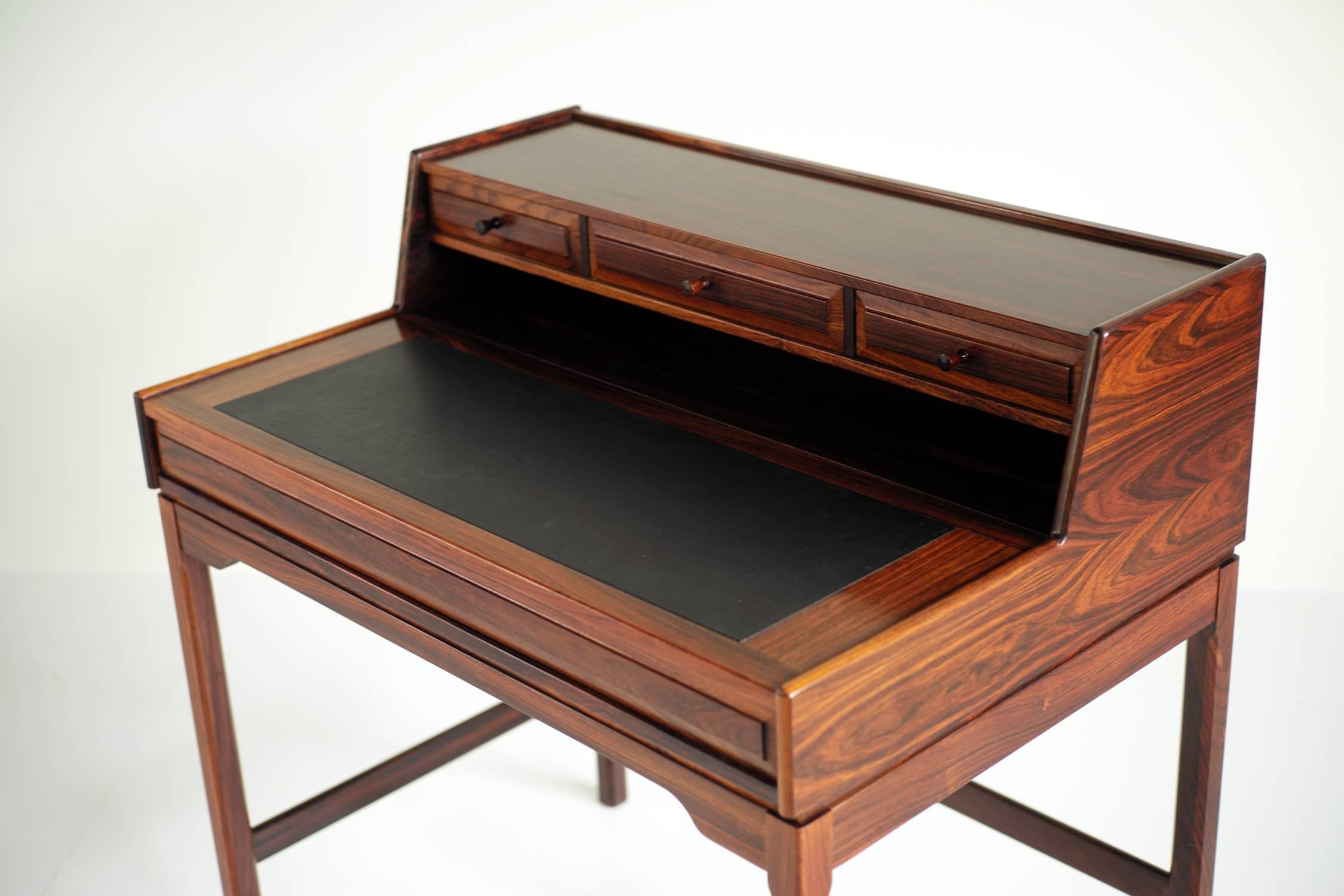 Refined in its smallest detail, this rare rosewood secretary is the work of Torbjørn Afdal for Bruksbo, Norway, 1960.
The flap tray is covered with black leather and reveals two compartments, three drawers are placed on the top panel.
Very good