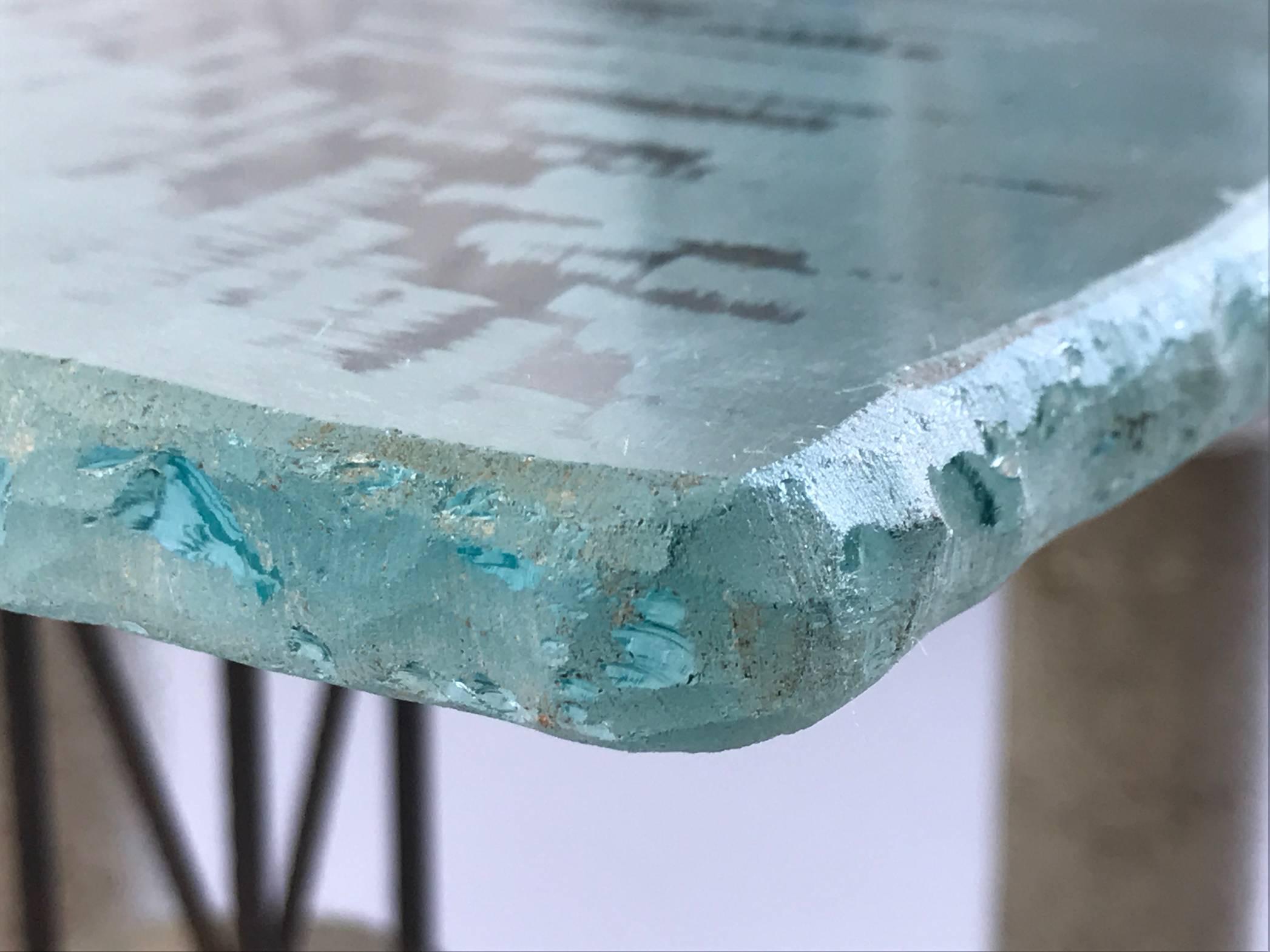 Rare glass table with concrete base and concrete iron. Provocative, aerial, this piece of the 80s does not leave indifferent. If the materials are raw, the finish is neat, the square glass slab is ground to its reverse, its chants are chiselled and