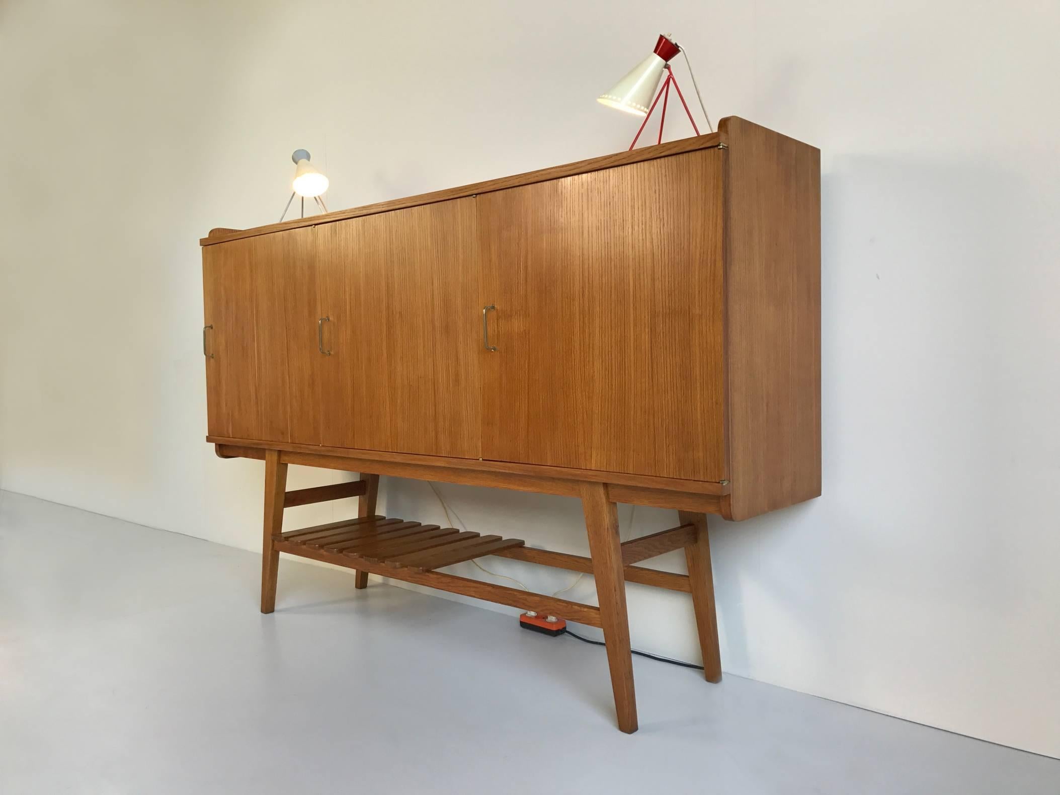 Dating from the period of the French reconstruction, this modernist three-door sideboard is the creation of Jean-René Caillette for Charron, France 1950.
The frame, partially covered with hurdles, is made of solid oak, the box made of oak veneer.