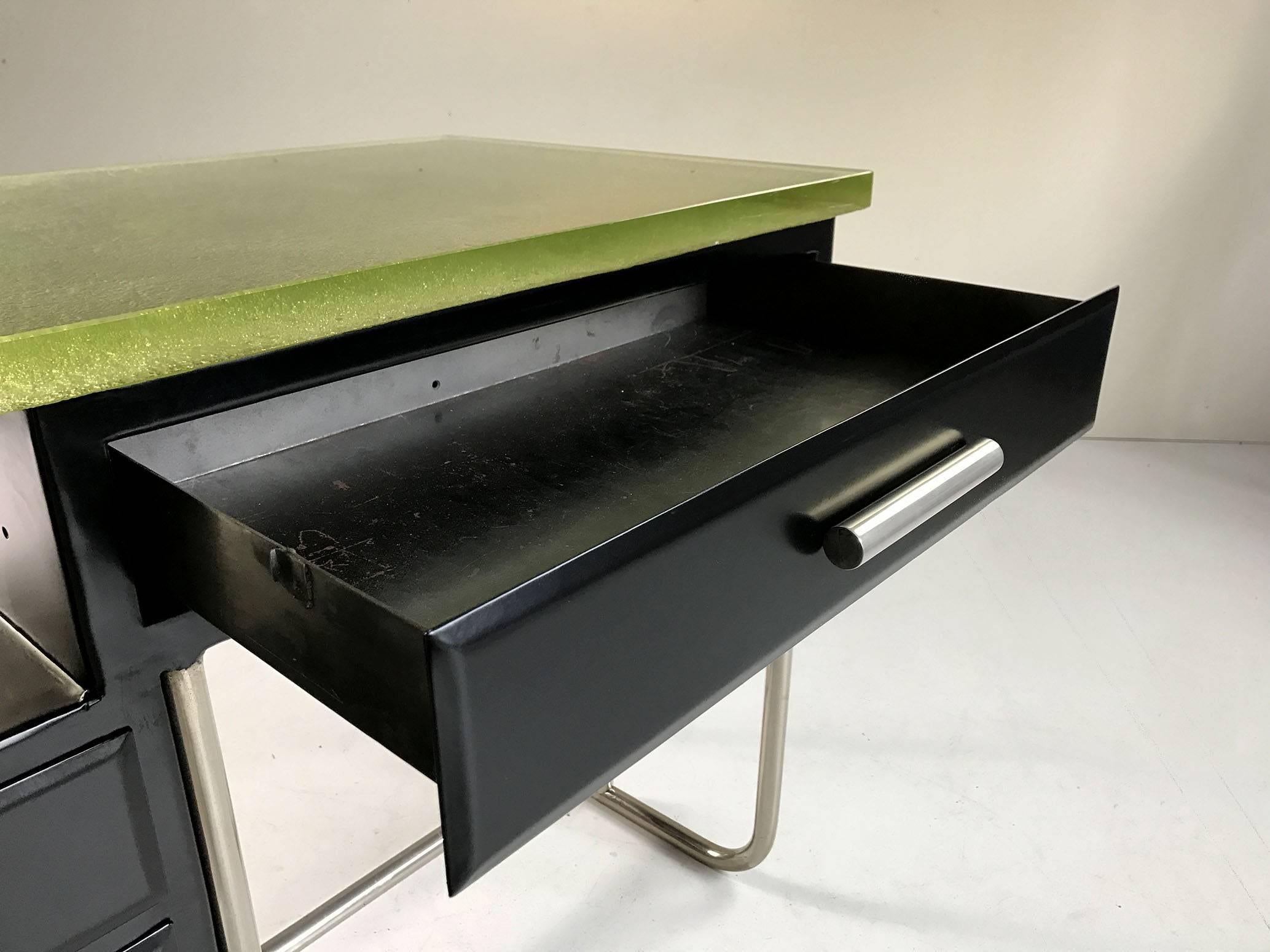 Rare modernist desk in black lacquered metal, Boussois glass top cast on sand citrine, 1930. The tubular base and handles are nickel-plated, the box has three drawers and a niche under the tray. 
A large drawer is arranged in a belt.
Very