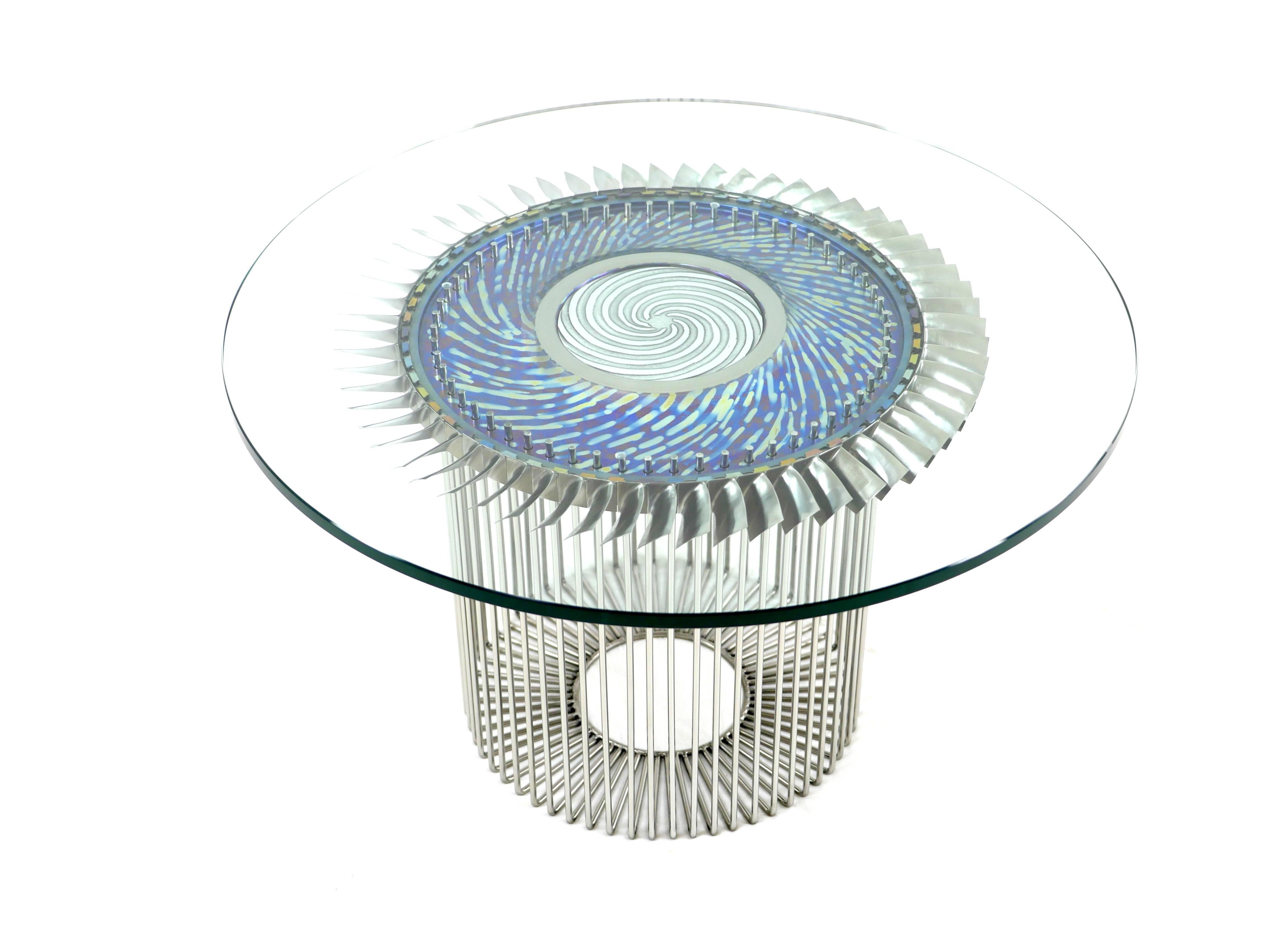 "Flower" coffee table made from airbus A340 turbo-fan. A mix of patinated titanium, stainless steel in glass.
The top is a 10 mm tempered glass, the fan is in patinated titanium and the base in polished stainless steel. Available