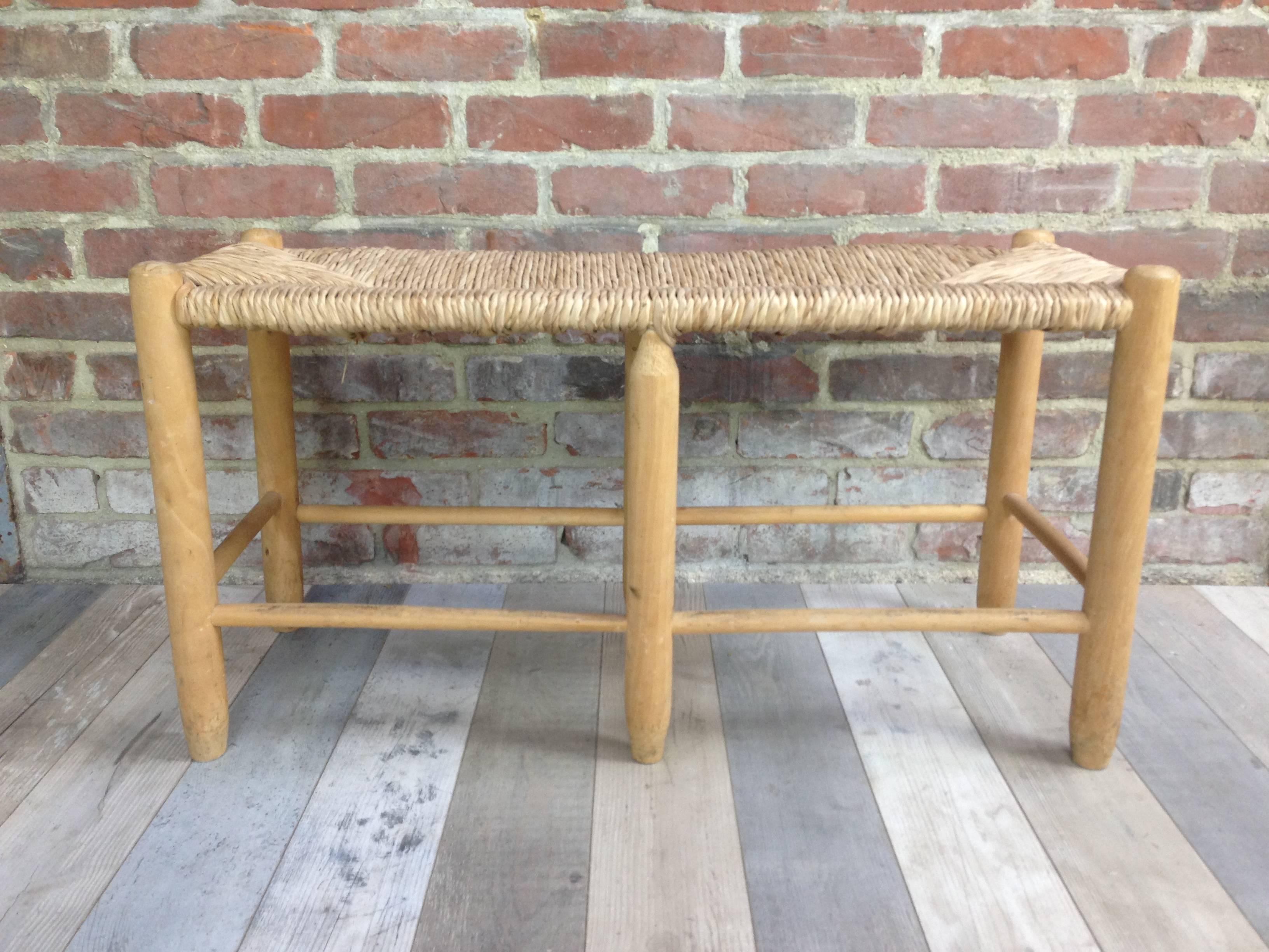 Bench in braided straw, arranged on a wooden structure forming a round base joined by spacers spacers with flat reception, in the manner of Charlotte Perriand for Steph Simon Edition.