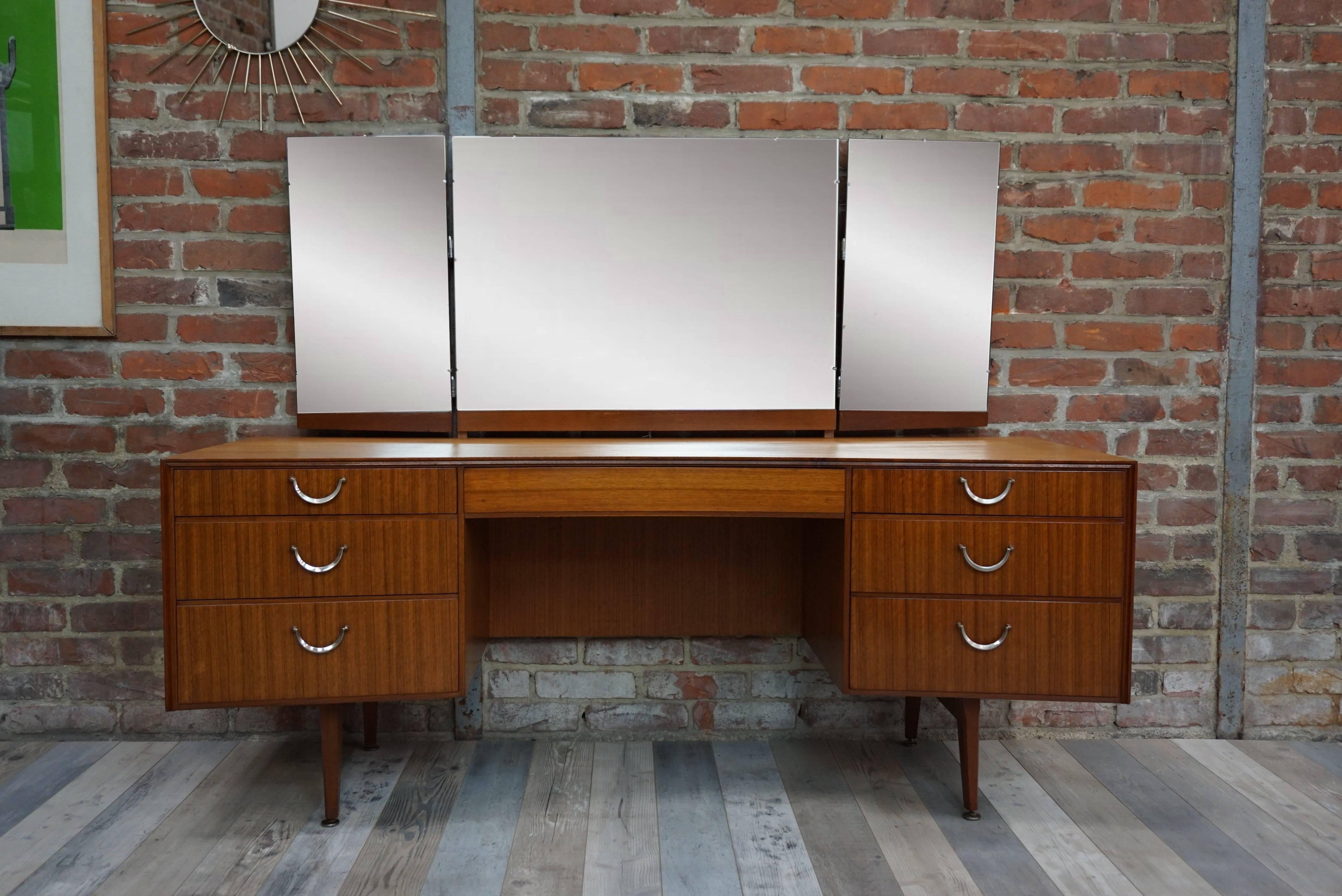 Sublime and rare teak furniture of the 1950s, to use in your entry, your living room or even your room it's up to you to recreate its history. Offering large storage spaces, sleek look, curved structure, with or without its triptych mirror, it will