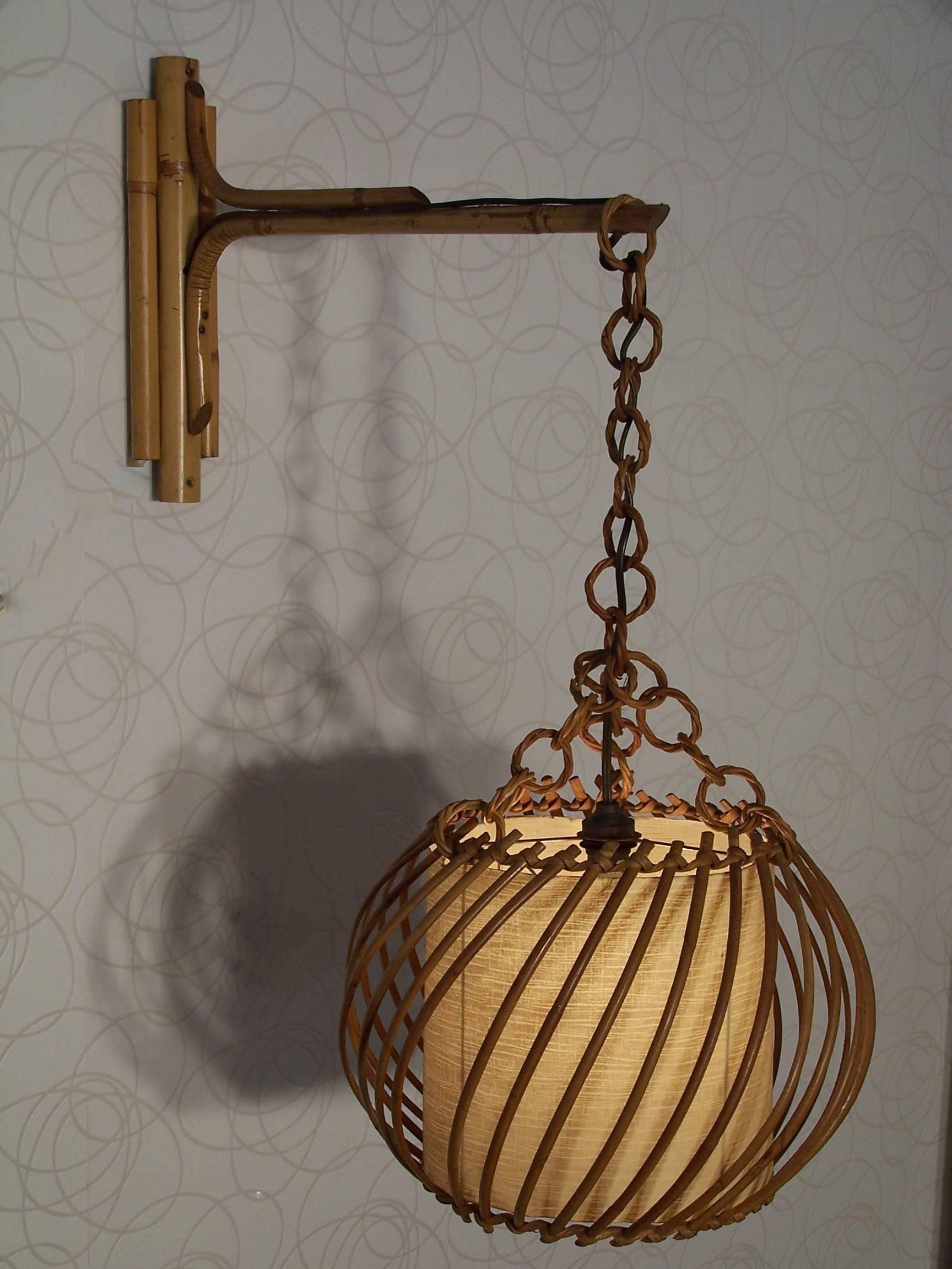 Adorable! This rattan, wood and paper wall / stem has a vintage look and a certain Scandinavian style. Its lampshade, all round (30cm diameter / 23cm high) made of paper and adorned with rattan, is maintained by the links of a wooden chain. The