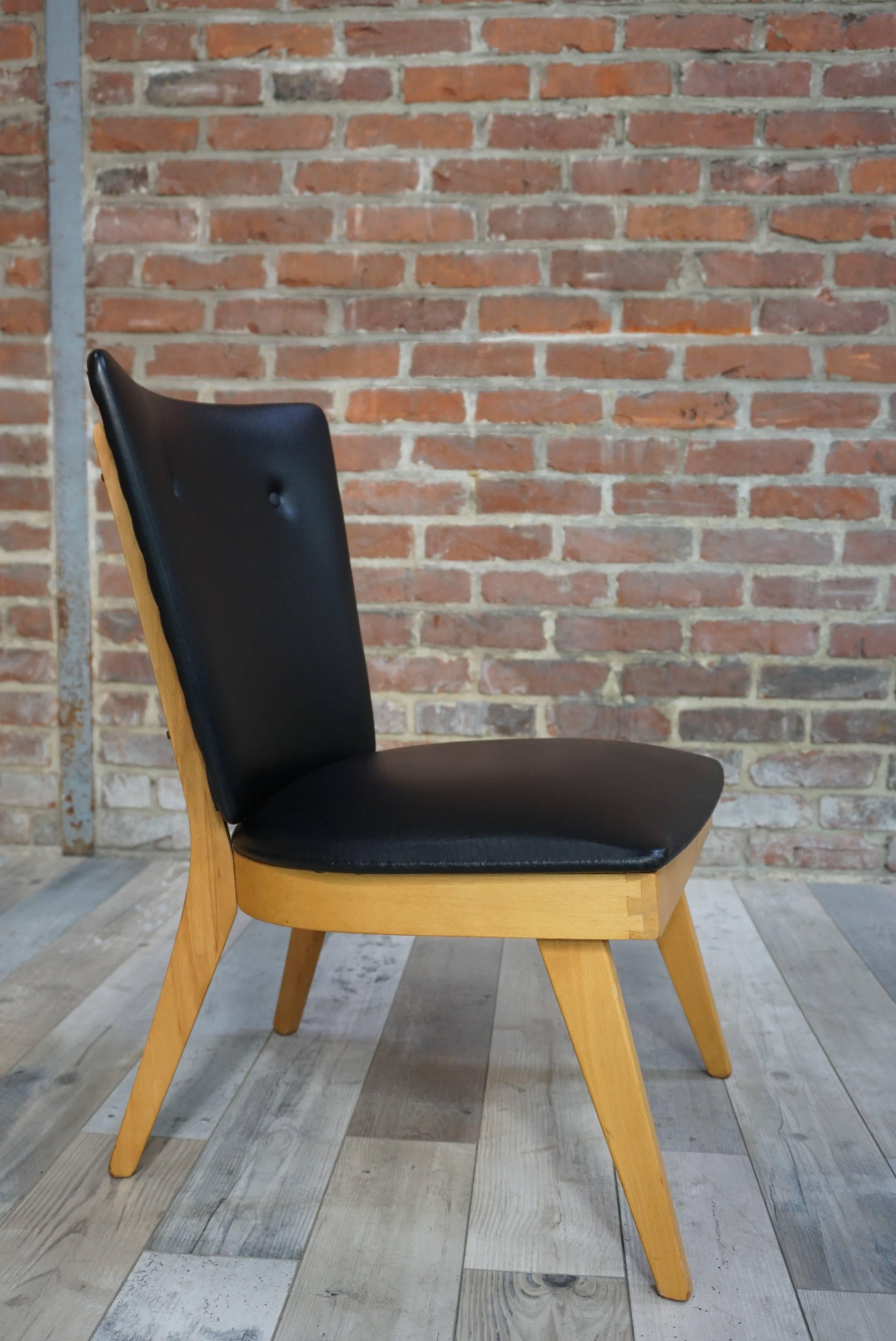 Adorable cocktail armchair from the 1950s, with wooden structure, compass feet, seat and curved back dressed in imitation black leather.