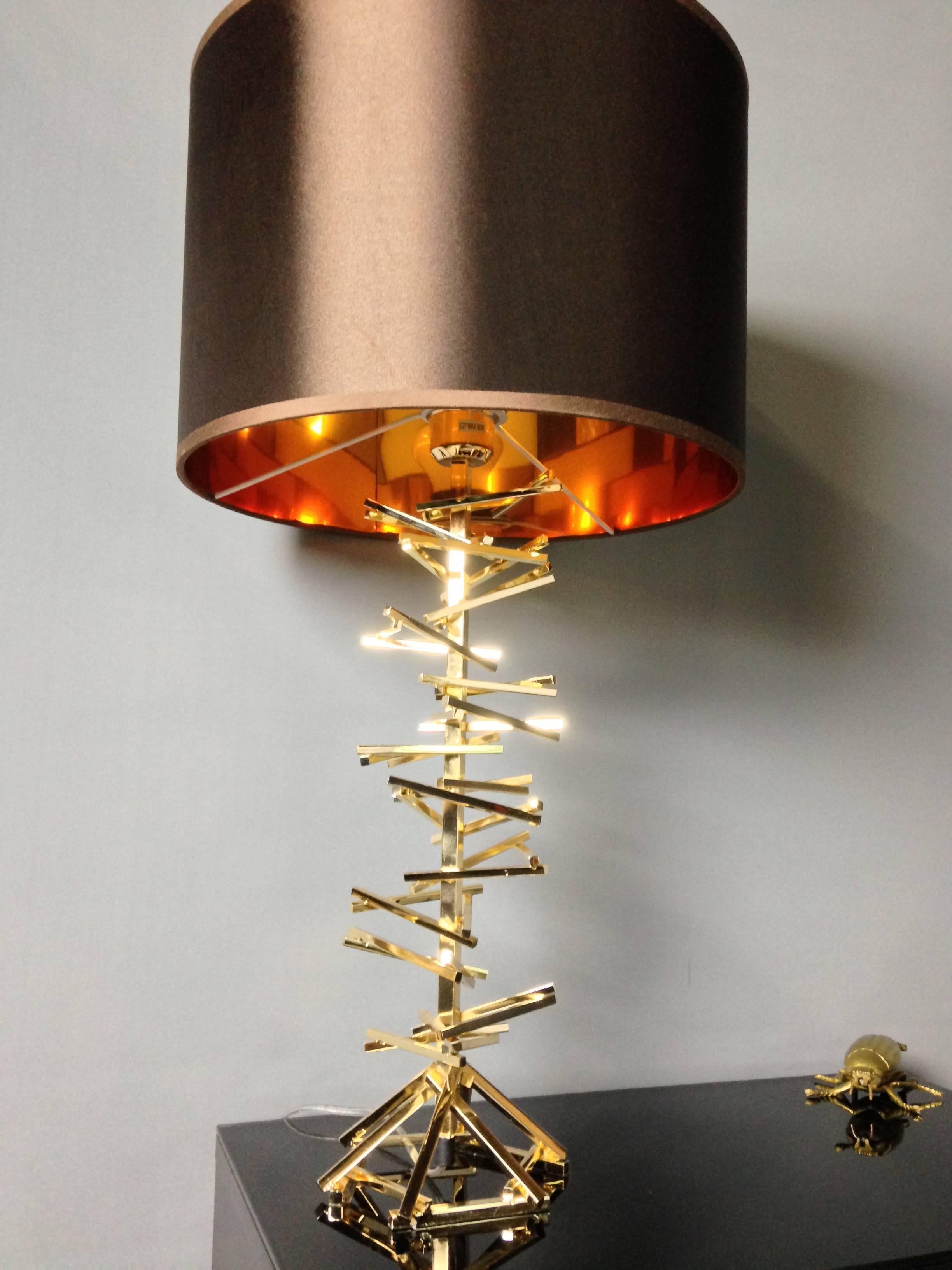 Golden metal table lamp with beautiful lampshade gold-tinted mirror effect inside.
