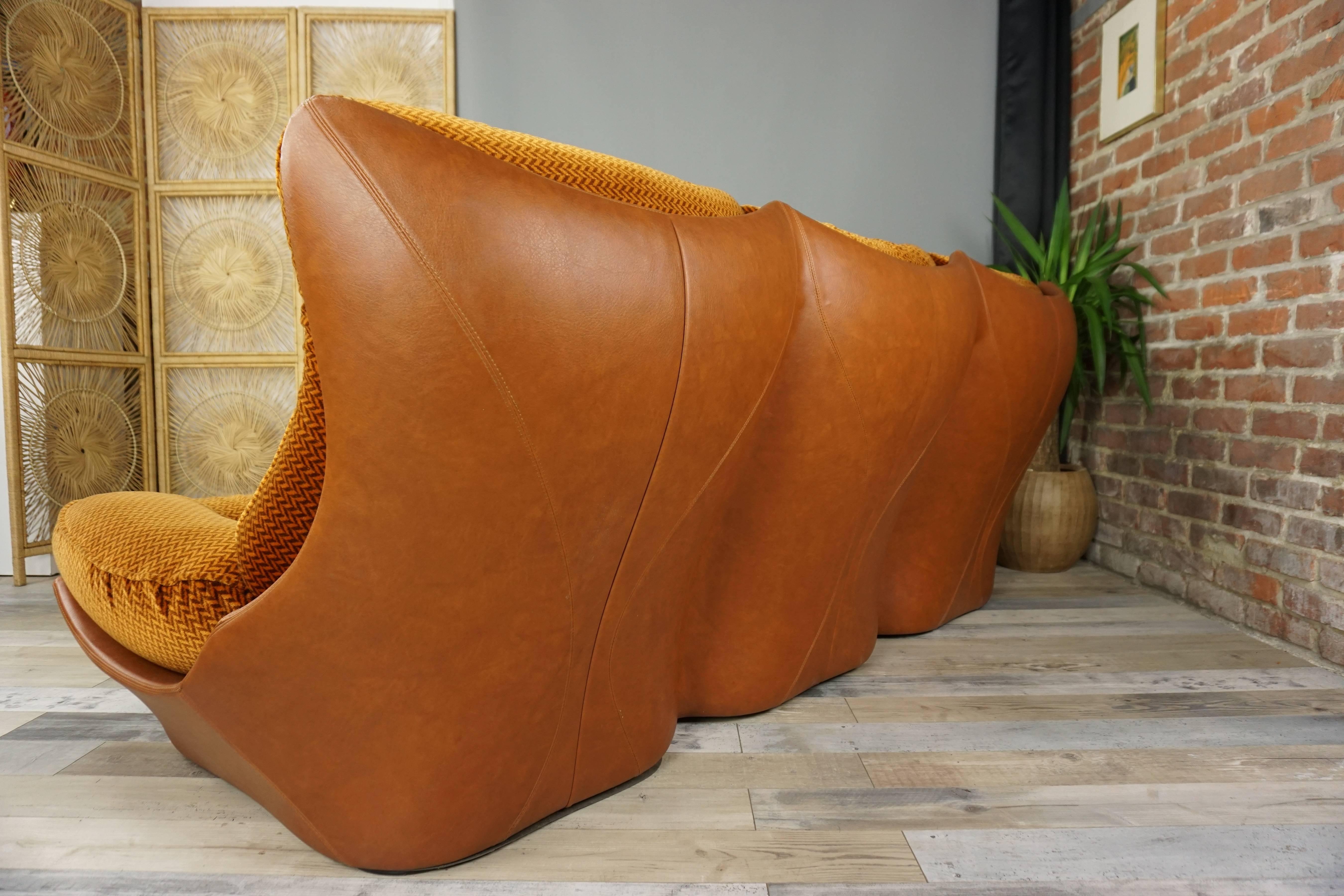 Space Age lounge lounge with a typical 1970s design consisting of a three-seat sofa and two large matching armchairs.

Coque covered with imitation leather cognac color, furnished with removable cushions and removable covers in psychedelic velvet