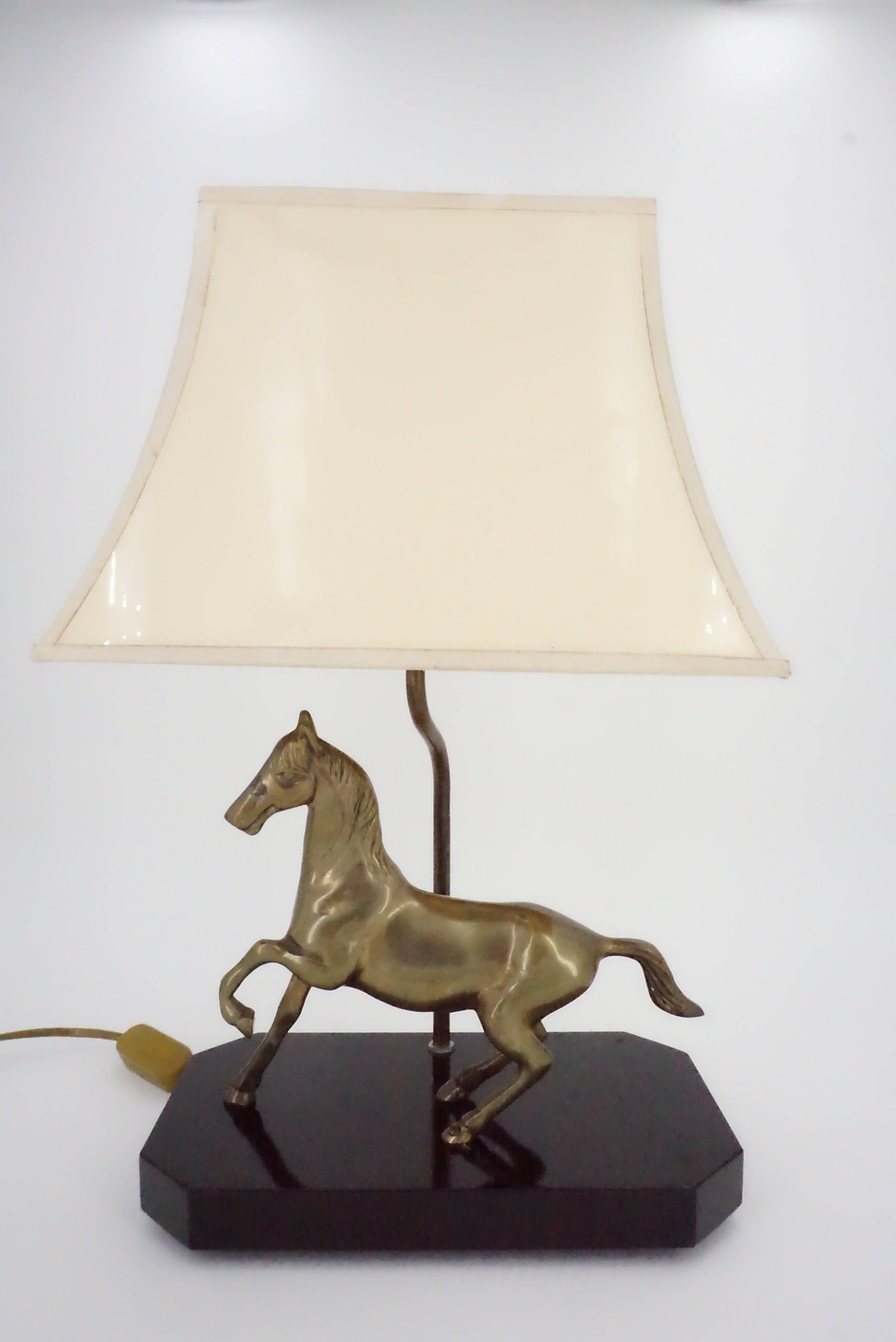 Lamp on hexagonal base in black lacquered wood, depicting a moving brass horse, adorned with an ivory and gold-colored pagoda lampshade inside, worthy of Maison Jansens and Charles ...