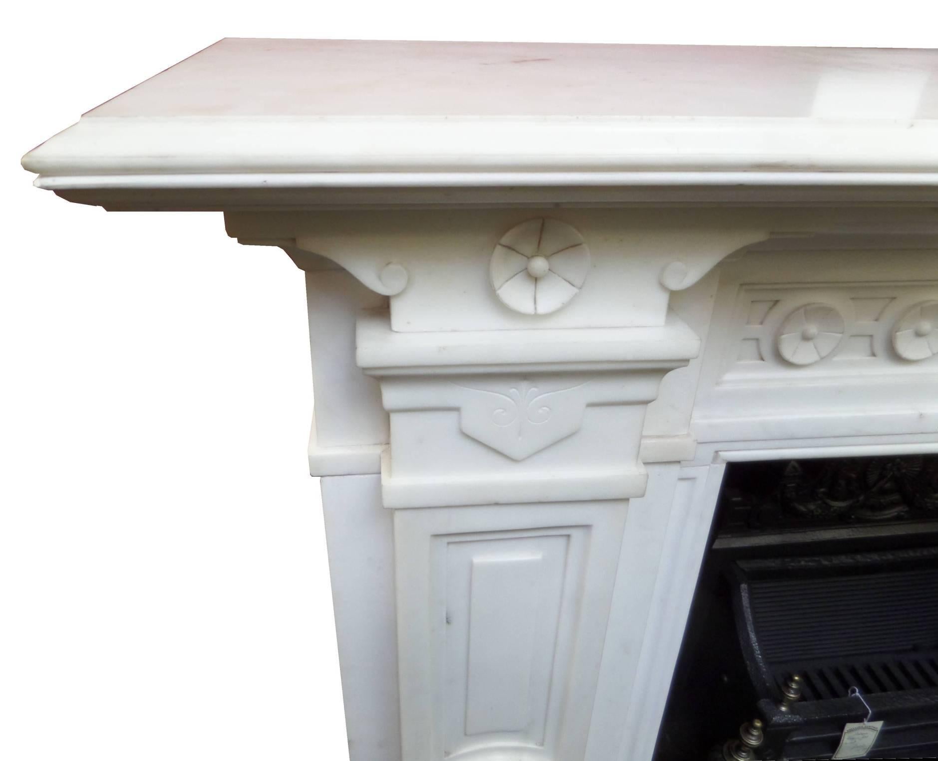 Antique restored grand statuary marble surround. This impressive antique surround is believed to have originated from the original Normanton Hall in Rutland, England. It boasts a double molded 77 x 16 inch shelf with impressive carved central tablet