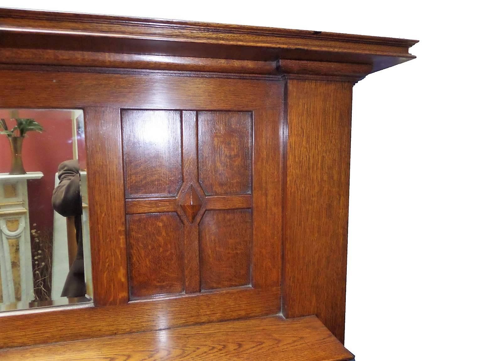 Antique restored Edwardian Arts and Crafts oakwood mantel or surround and mirror, circa 1910. Panelled design typical of the arts and craft period along with original mirror.