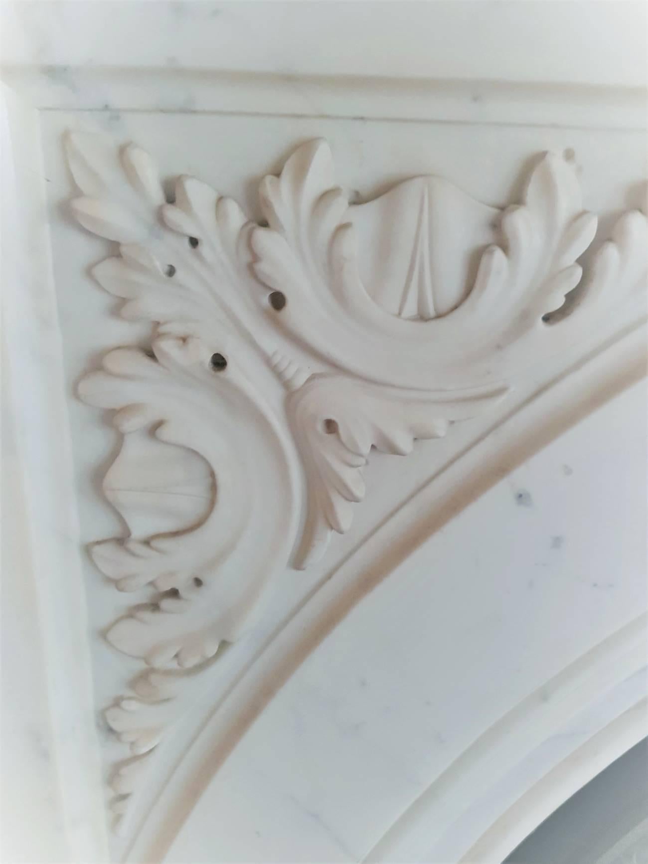 19th century restored large Victorian arched Carrara marble chimney piece, This piece is complete with its original arched cast iron fireplace insert and marble fender, date circa 1860.