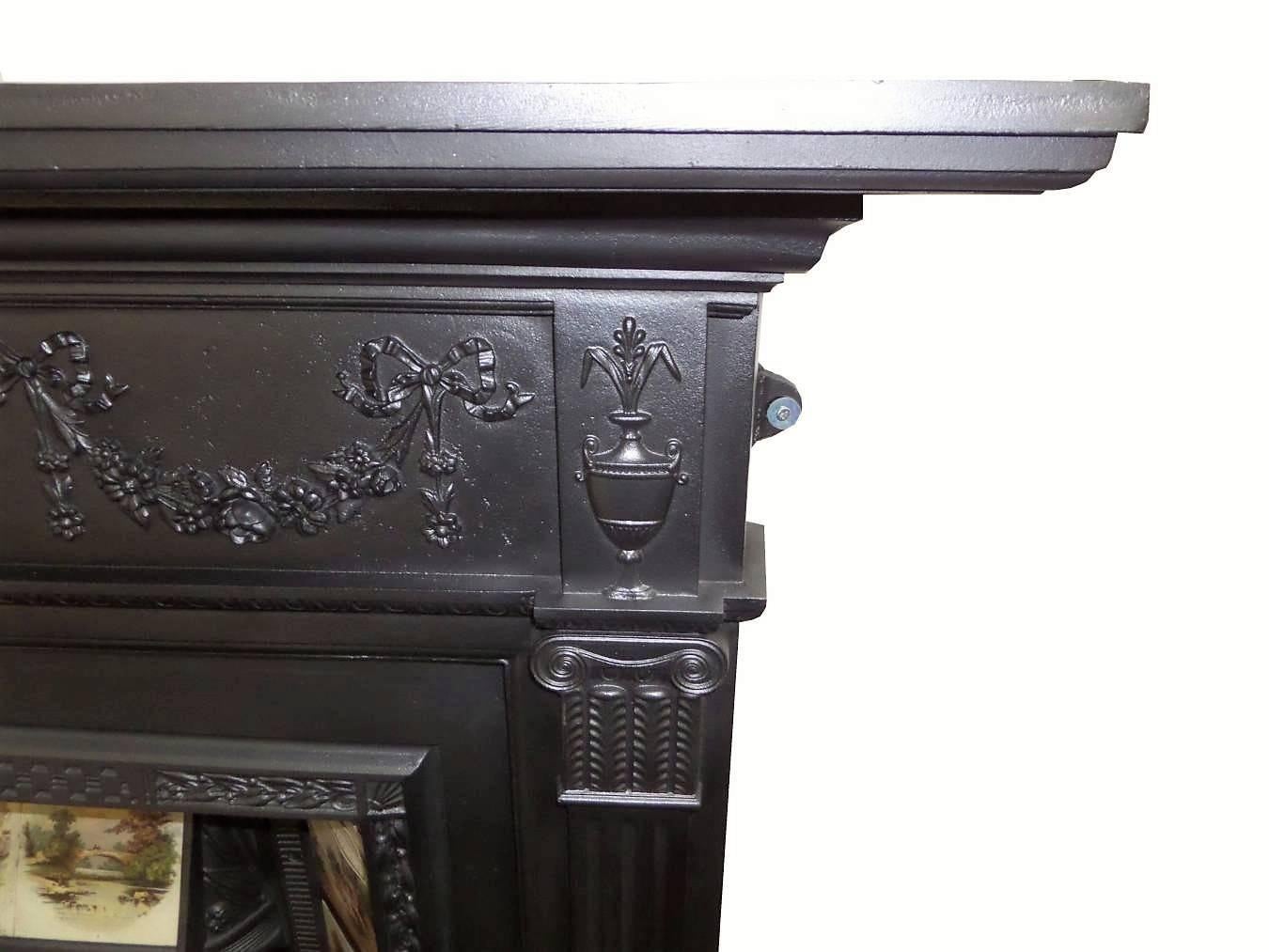 Antique restored 19th century Victorian cast iron surround, circa 1880. Neoclassical in design with detailing to include urn to the frieze and Classic bows and swags.
The surround is pictured with a Victorian cast iron and tiled grate sold
