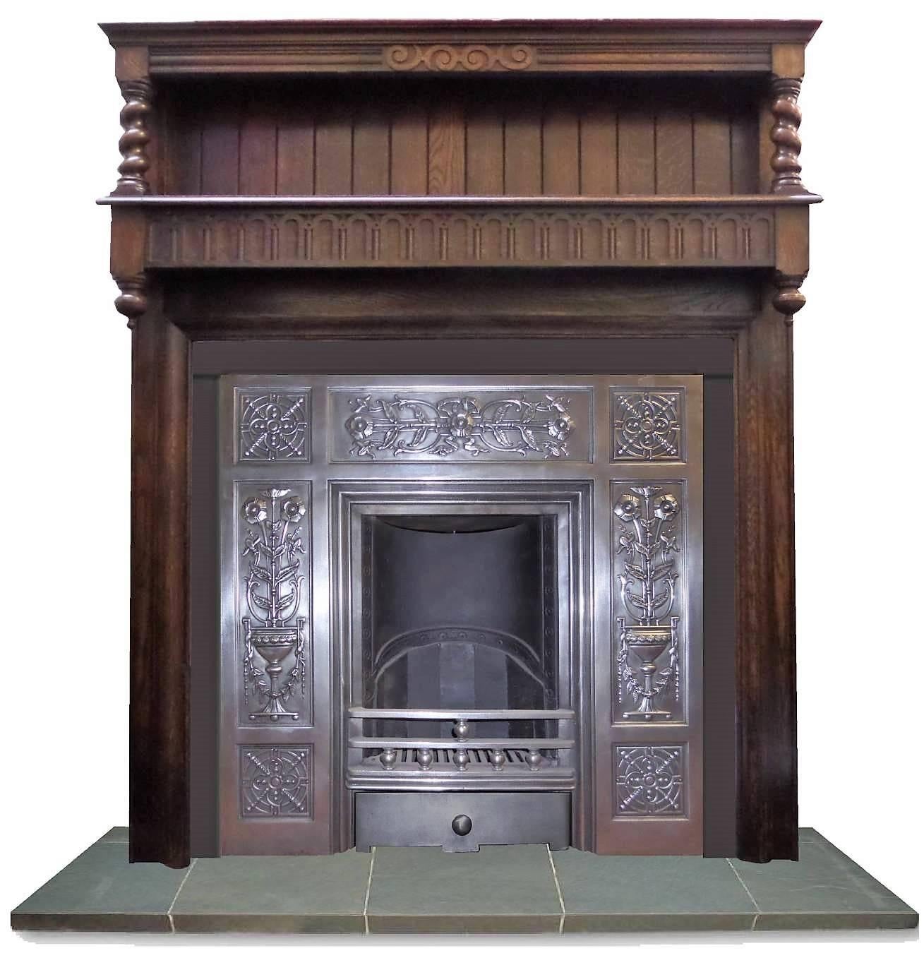Antique restored 20th century oak Arts & Craft style wood surround, dark oak grain with impressive spindle and Arts & Craft paneling and carving. Can be adjusted to suit most insert, date circa 1915.