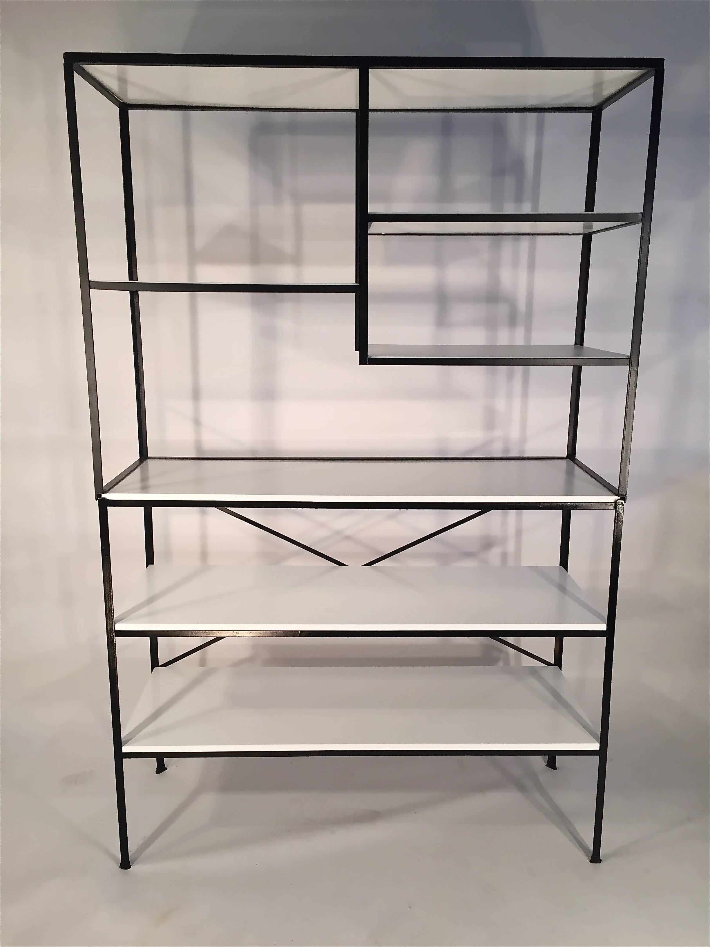 Frederick Weinberg iron and Masonite shelf unit from the 1950s. This is restored with black lacquer on the iron frame and bright white lacquer on the Masonite shelves. The iron frame of this unit is in two pieces with the top half being able to lift