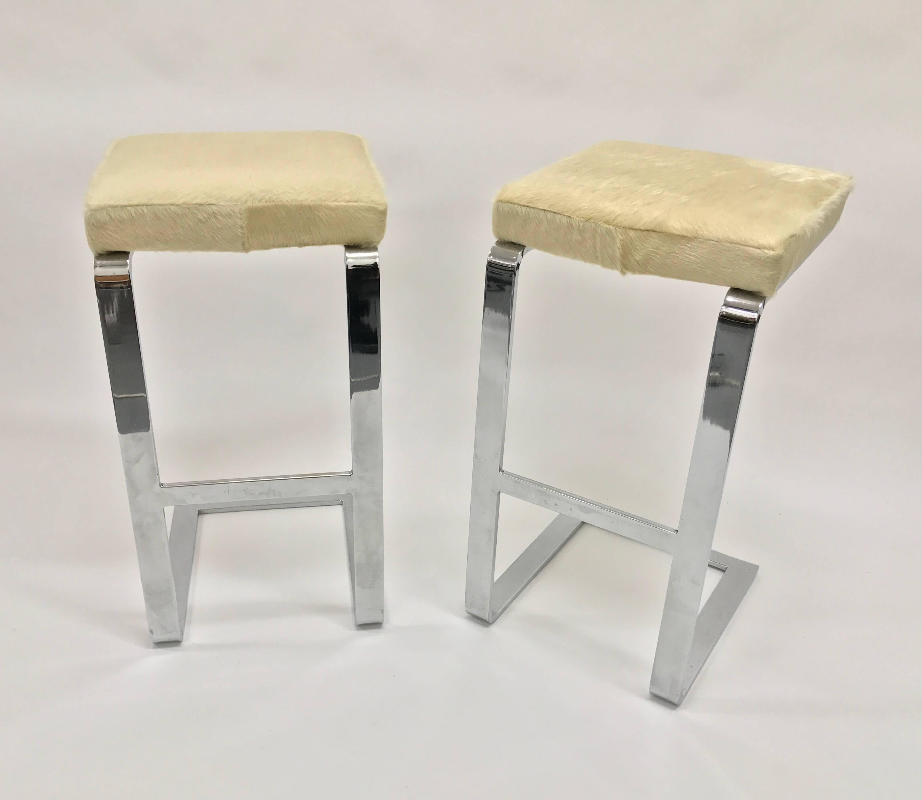 Pair of chrome flat bar cantilever bar stools with cowhide covered seats by Pace Collection, 1980s.