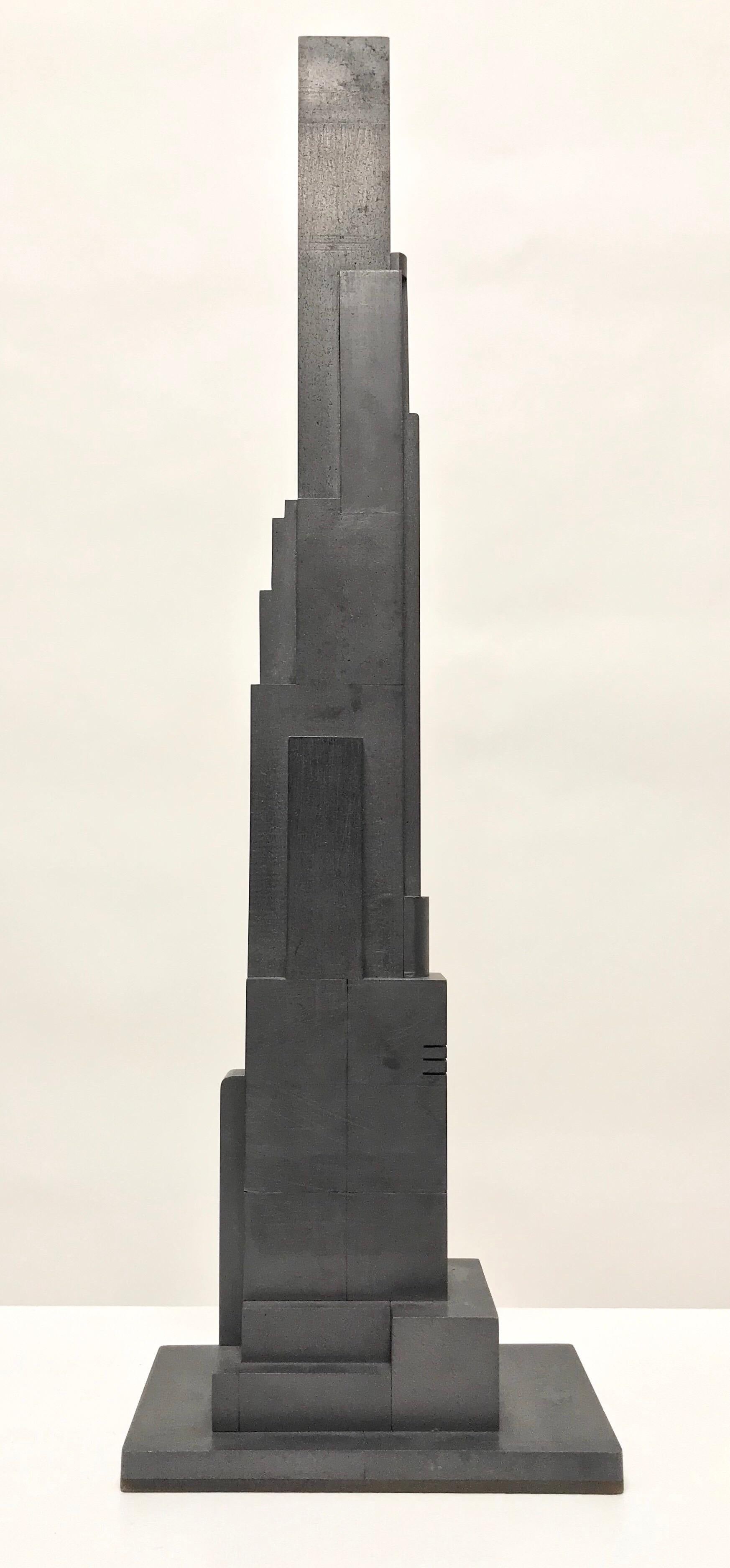 Skyscraper sculpture with a geometric form made of cast graphite.