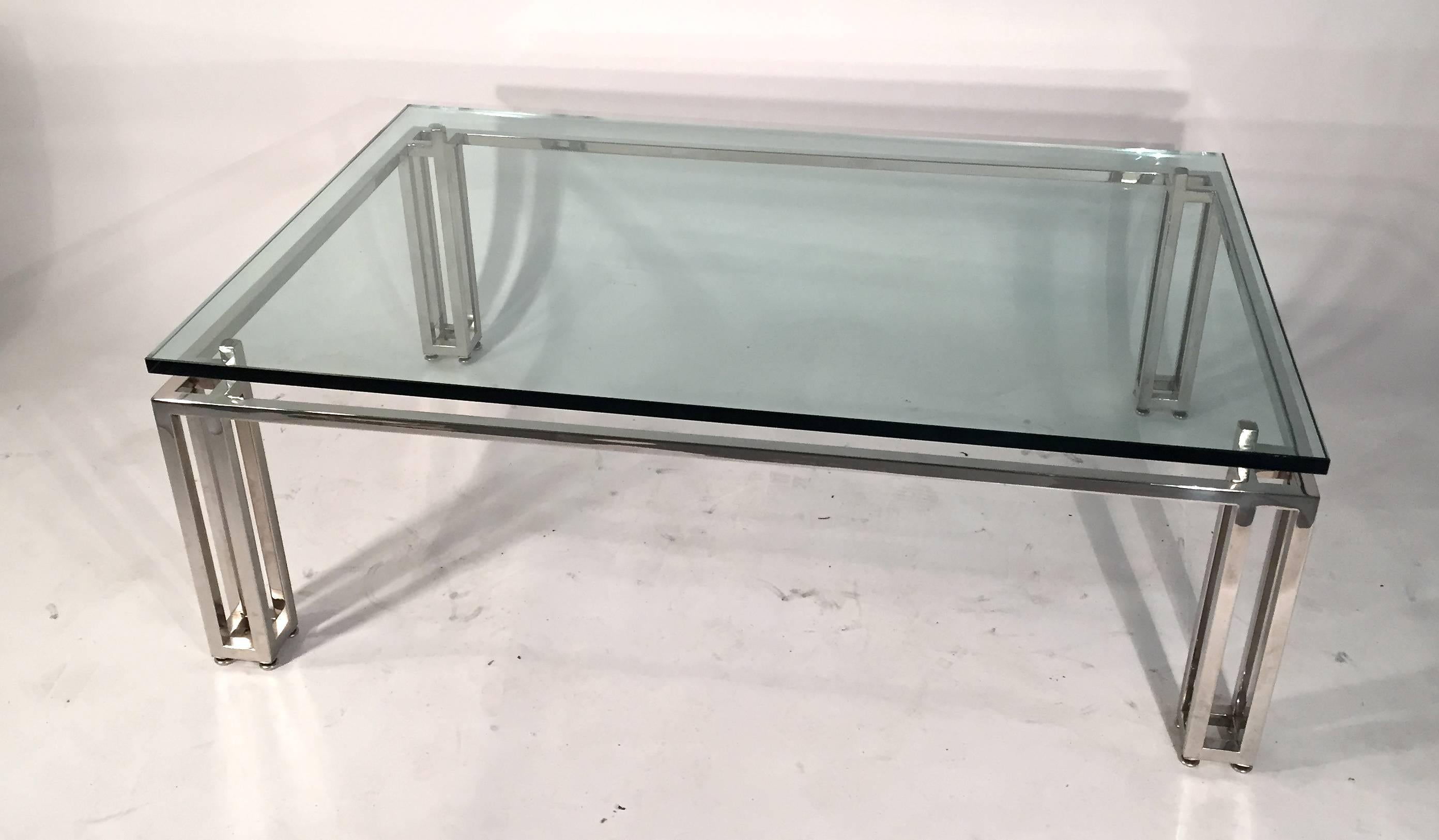 Chrome base coffee table with a floating glass top.