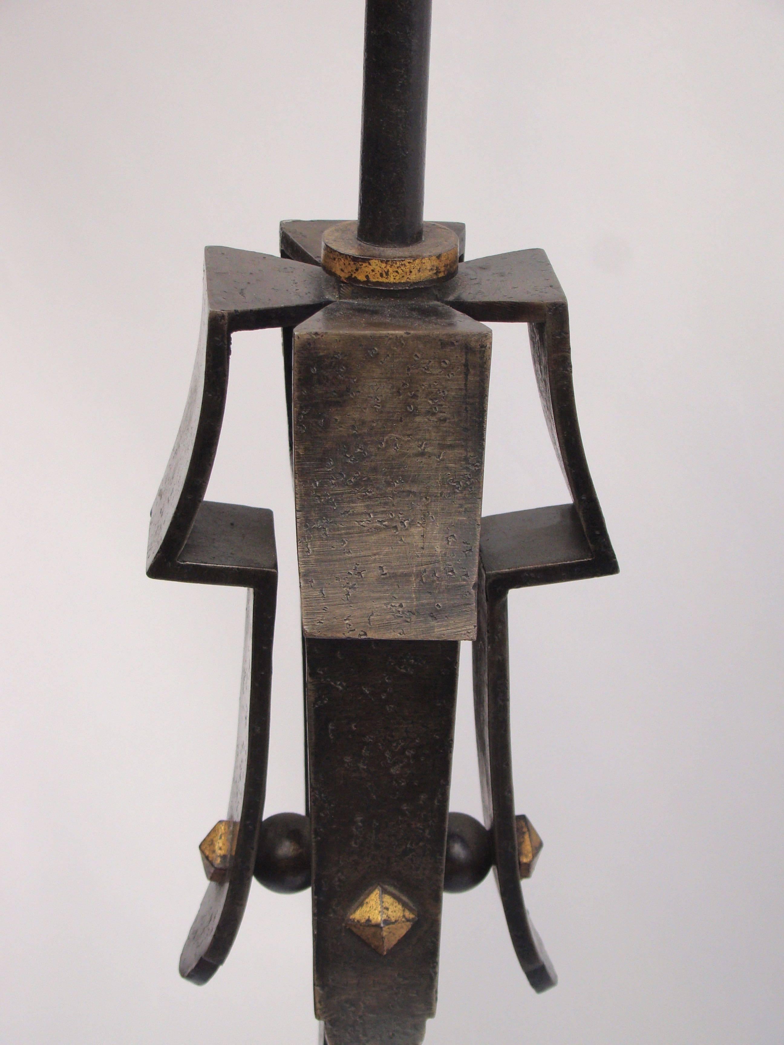 French black burnished wrought iron floor lamp by C.A.F, (Compagnie des Arts Français), Jacques Adnet, circa 1940 with a four legs base, a twisted pattern at mid-height and a nailed pattern in a black and gold wrought iron.
