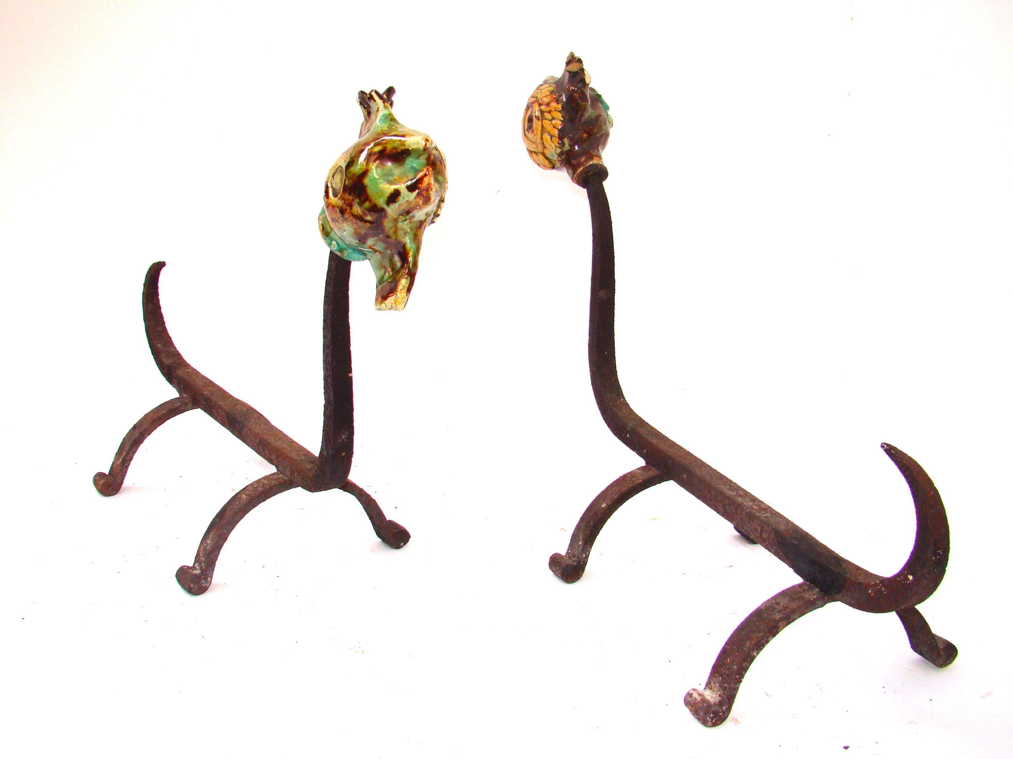 French hand-forged iron pair of andirons with polychromatic ceramics rooster feature, circa 1950.