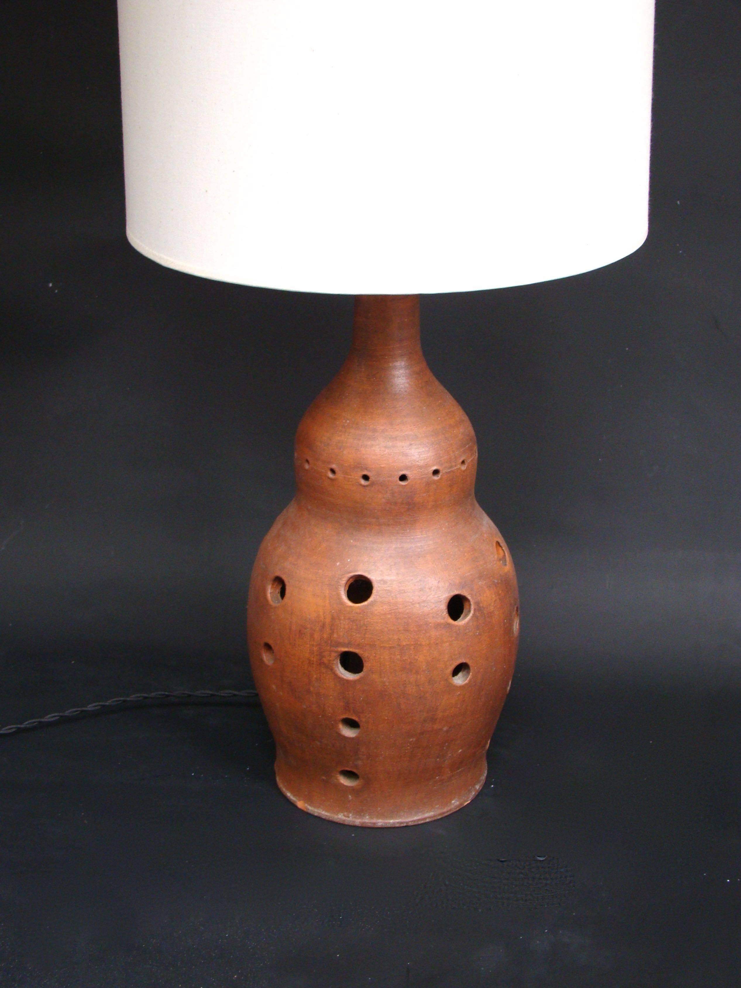 Elegant table lamp in terra cotta figuring a flask shade, circa 1950.

Height: 73 cm with the shade.