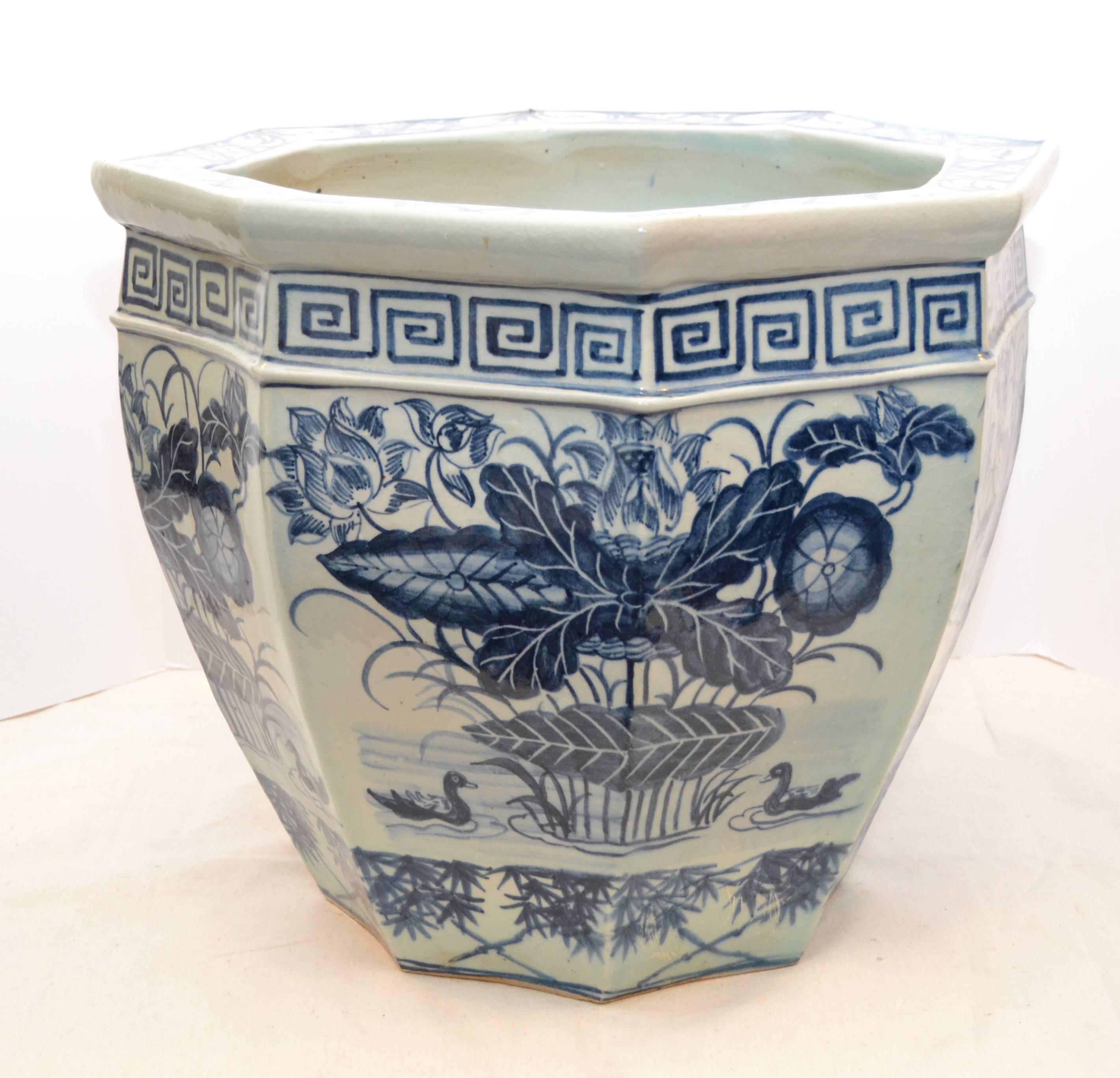 Pair of Chinese blue and white octagonal fish bowls with water lily and waterfowl motifs. Greek key motif around neck.